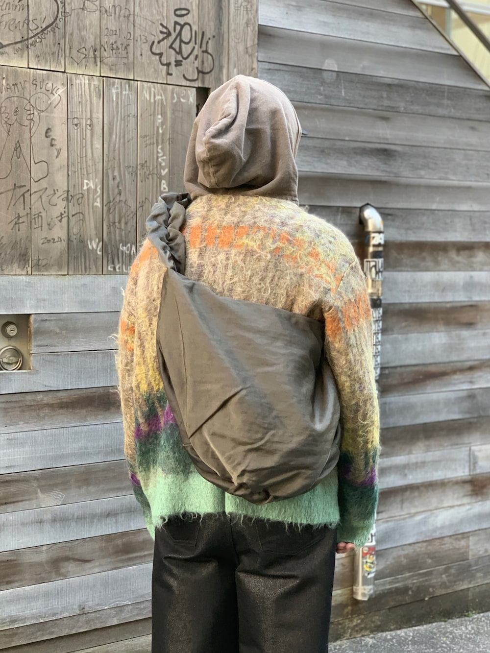 ブラック系のドレスシューズ、ブラック系のデニムパンツ、ブラウン系のパーカーを着用したメンズの冬コーディネートの2枚目の写真