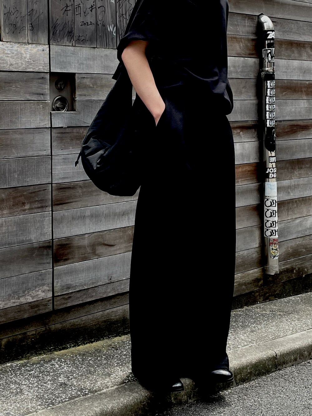 ブラック系のTシャツ/カットソー、ブラック系のスラックスを着用したメンズの夏コーディネートの2枚目の写真