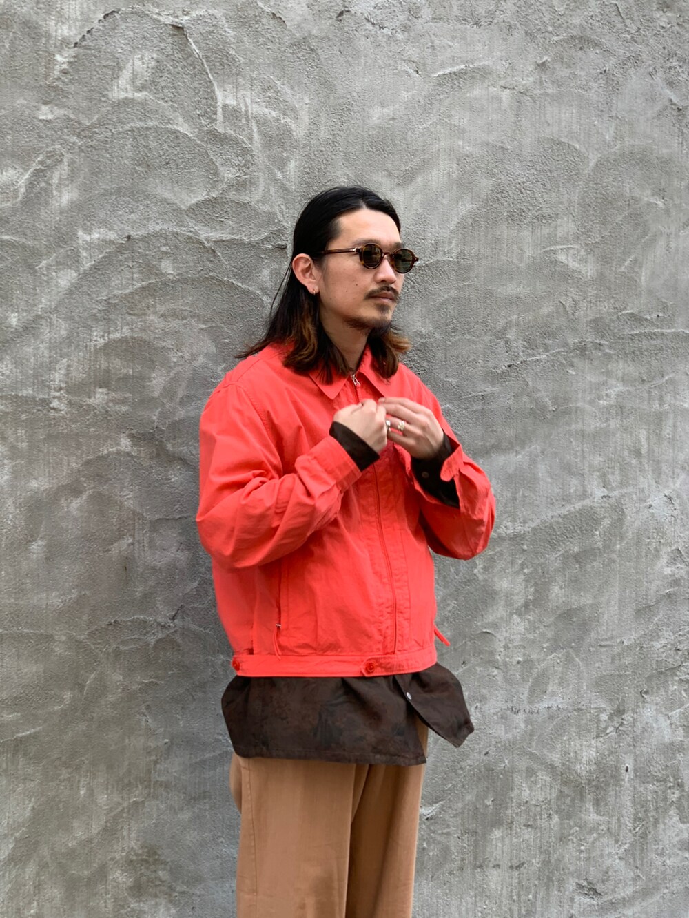 ベージュ系のパンツ、ブラウン系のトップス、ピンク系のジャケット/アウターを着用したメンズの春コーディネートの2枚目の写真