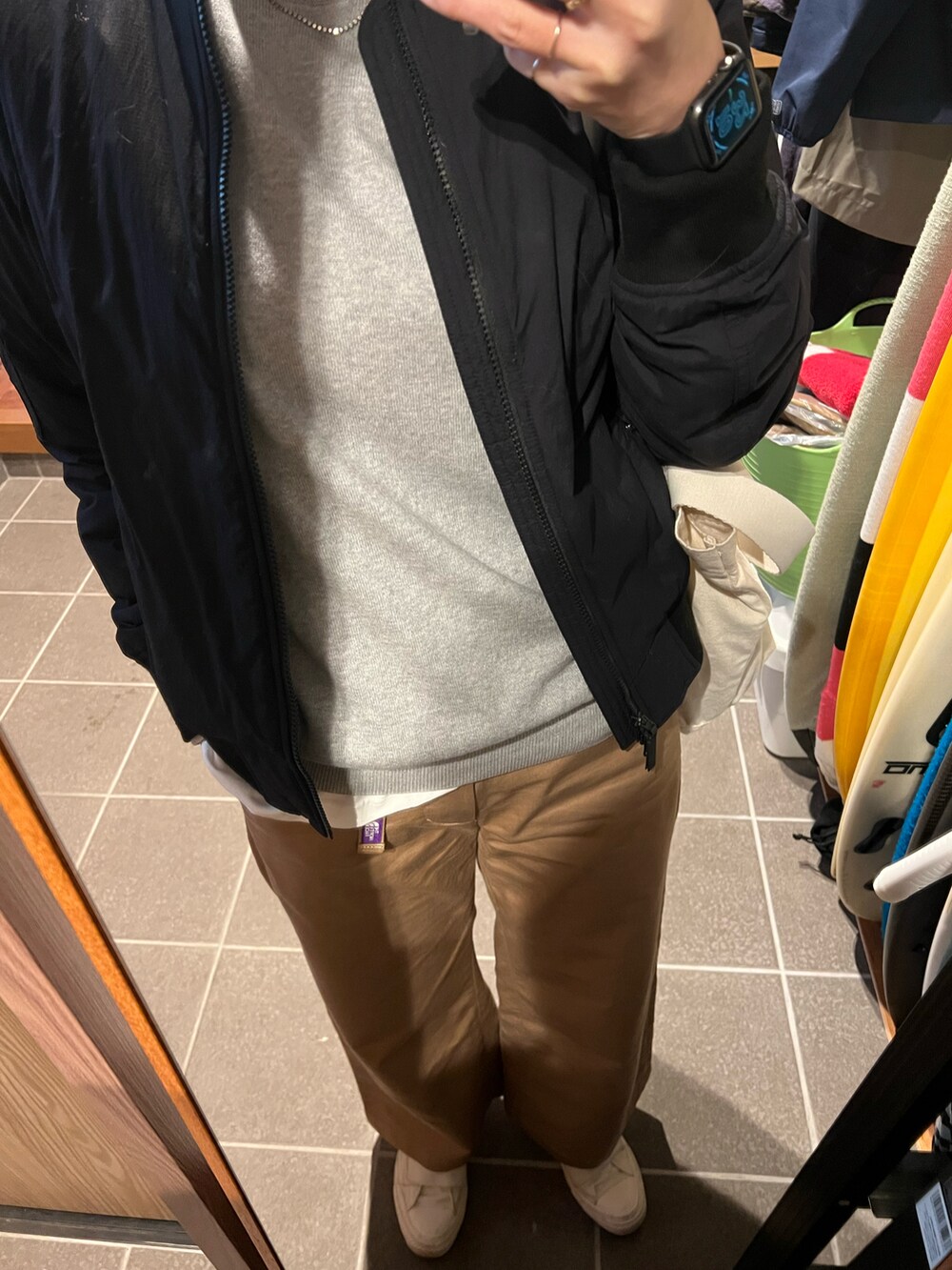 ブラック系のナイロンジャケット、ホワイト系のスニーカーを着用したレディースの春コーディネートの2枚目の写真