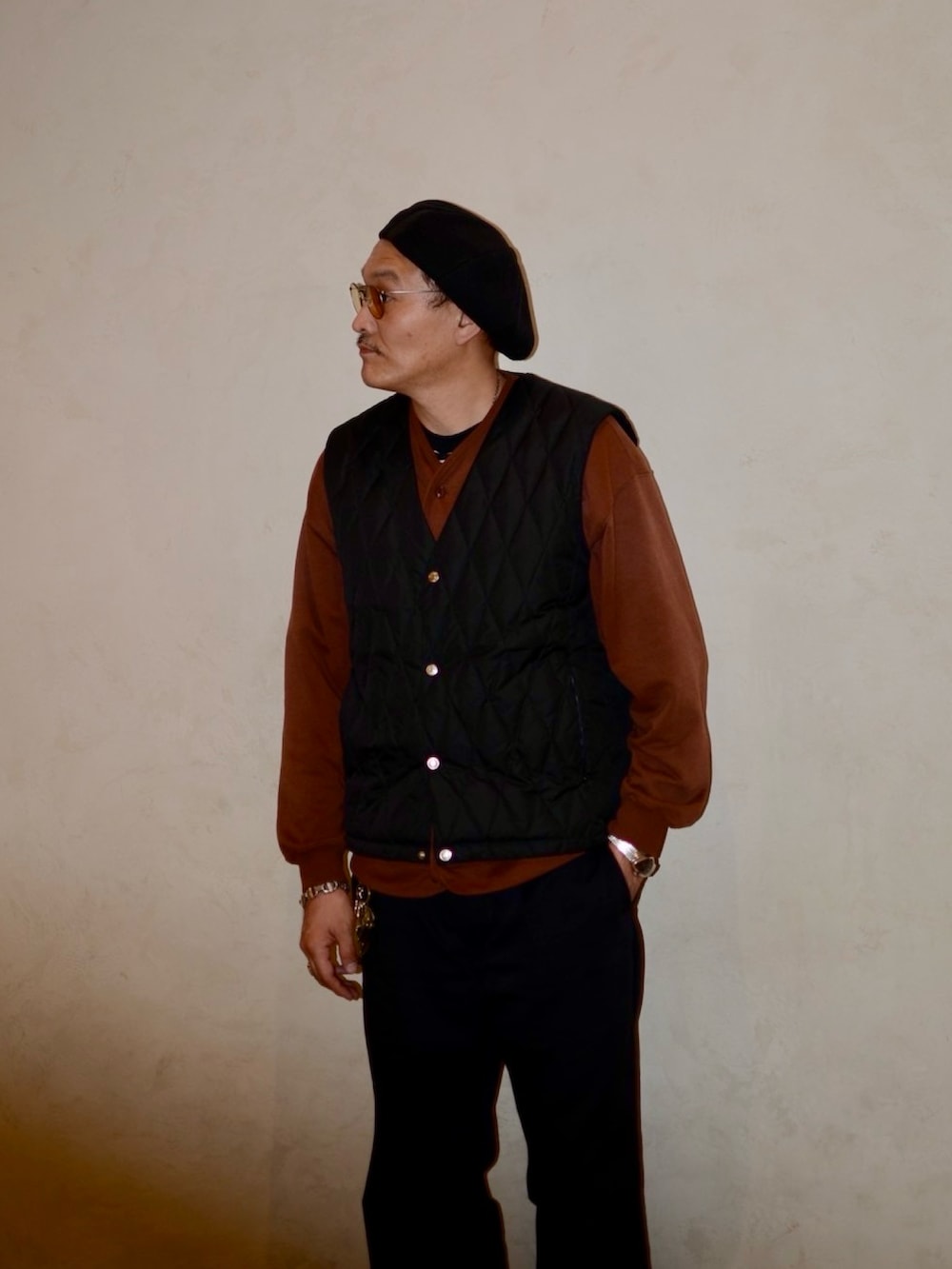 ブラウン系のカーディガン/ボレロ、ブラック系のダウンベスト、ブラック系のその他パンツを着用したメンズの秋コーディネートの4枚目の写真