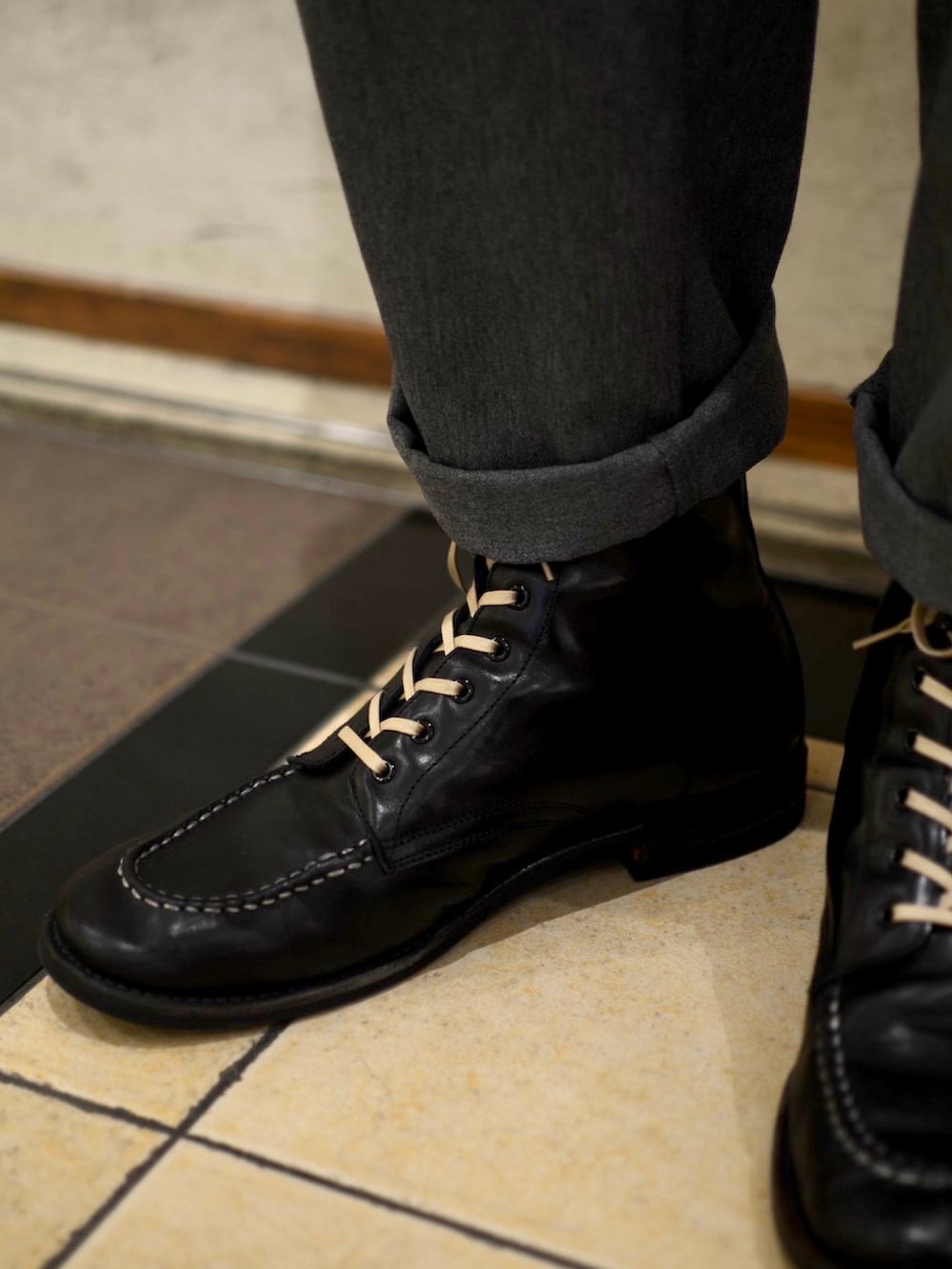 ブラック系のテーラードジャケット、ベージュ系のTシャツ/カットソー、グレー系のチノパンツを着用したメンズの冬コーディネートの4枚目の写真