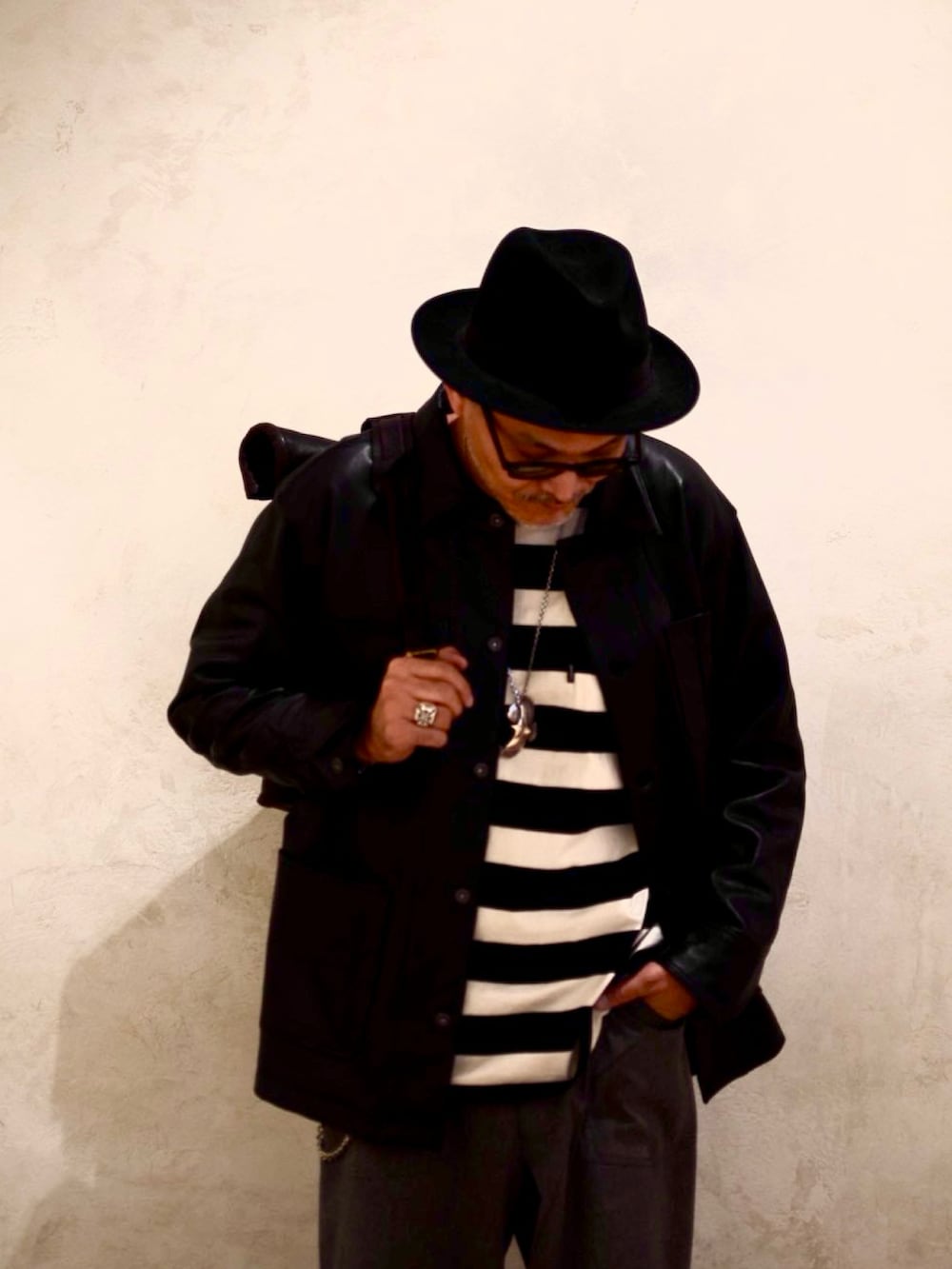 ブラック系のライダースジャケット、ブラック系のTシャツ/カットソー、ブラック系のバックパック/リュックを着用したメンズの春コーディネートの4枚目の写真