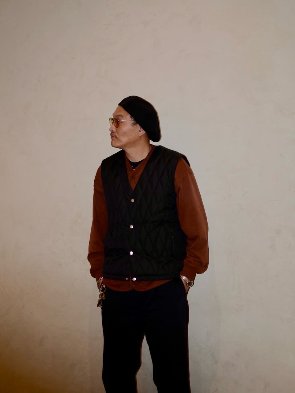 ブラウン系のカーディガン/ボレロ、ブラック系のダウンベスト、ブラック系のその他パンツを着用したメンズの秋コーディネートの2枚目の写真