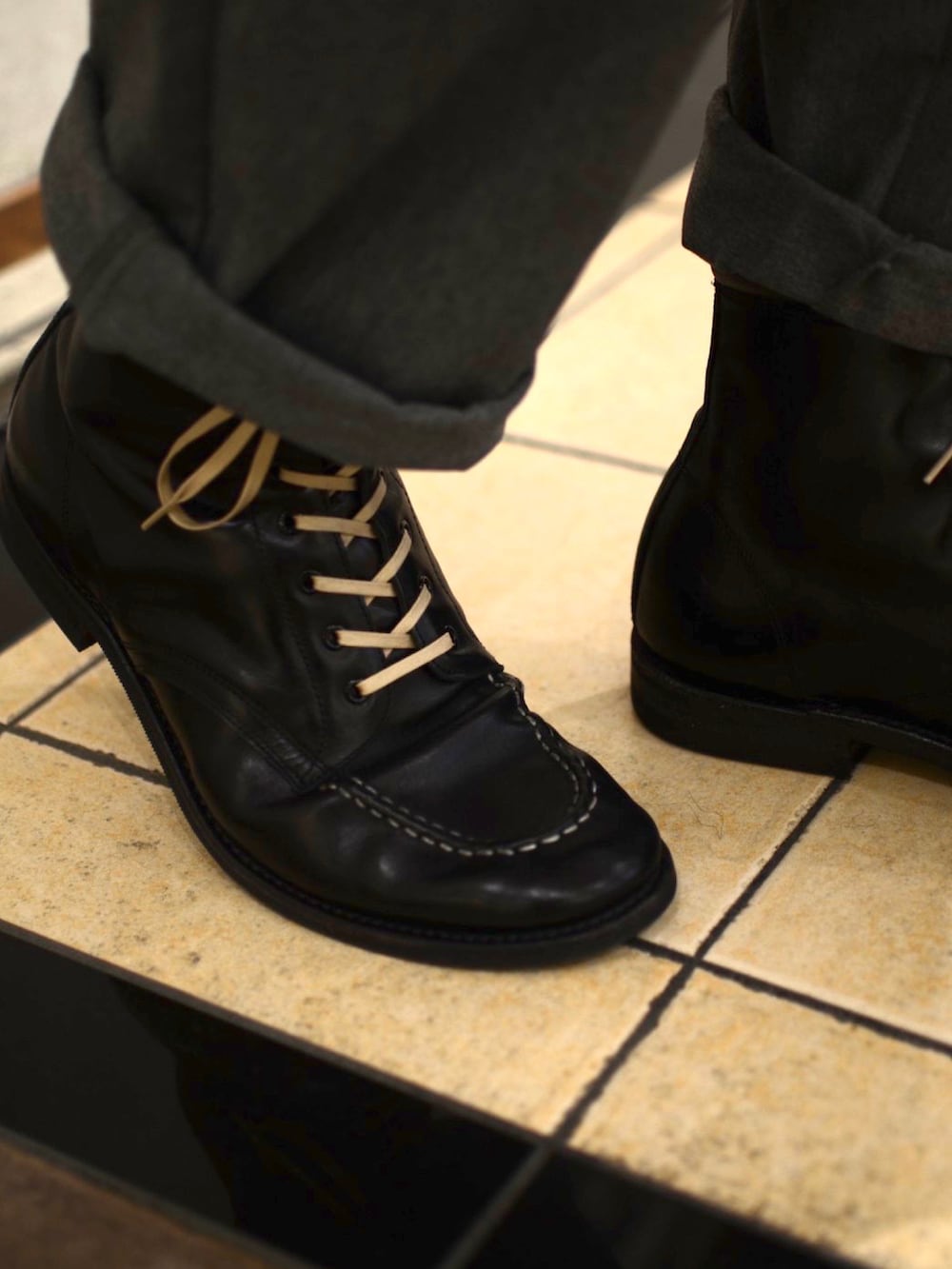 ブラック系のテーラードジャケット、ベージュ系のTシャツ/カットソー、グレー系のチノパンツを着用したメンズの冬コーディネートの3枚目の写真