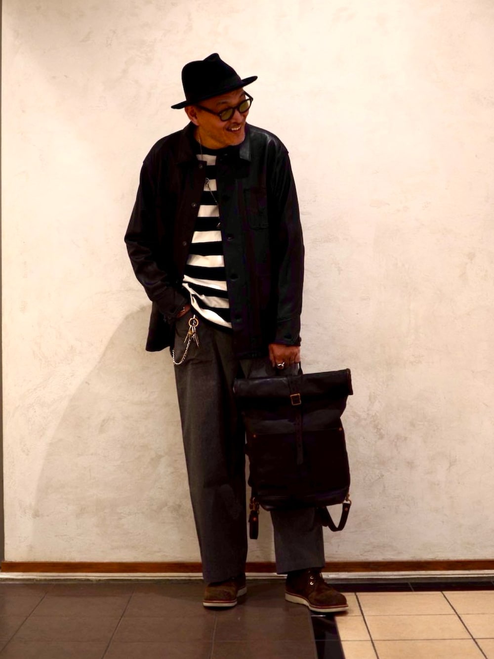 ブラック系のライダースジャケット、ブラック系のTシャツ/カットソー、ブラック系のバックパック/リュックを着用したメンズの春コーディネートの2枚目の写真