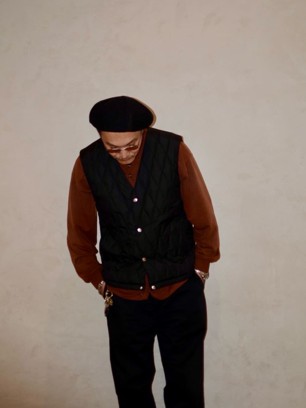 ブラウン系のカーディガン/ボレロ、ブラック系のダウンベスト、ブラック系のその他パンツを着用したメンズの秋コーディネートの3枚目の写真