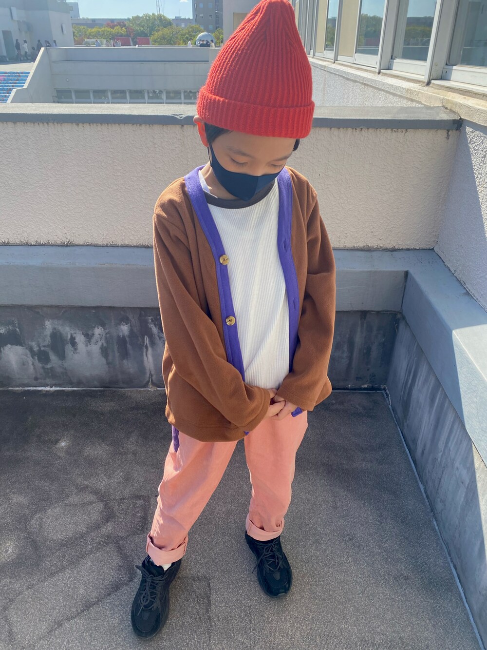 グレー系のスニーカー、ブラウン系のカーディガン/ボレロ、ホワイト系のTシャツ/カットソーを着用したキッズの秋コーディネートの2枚目の写真