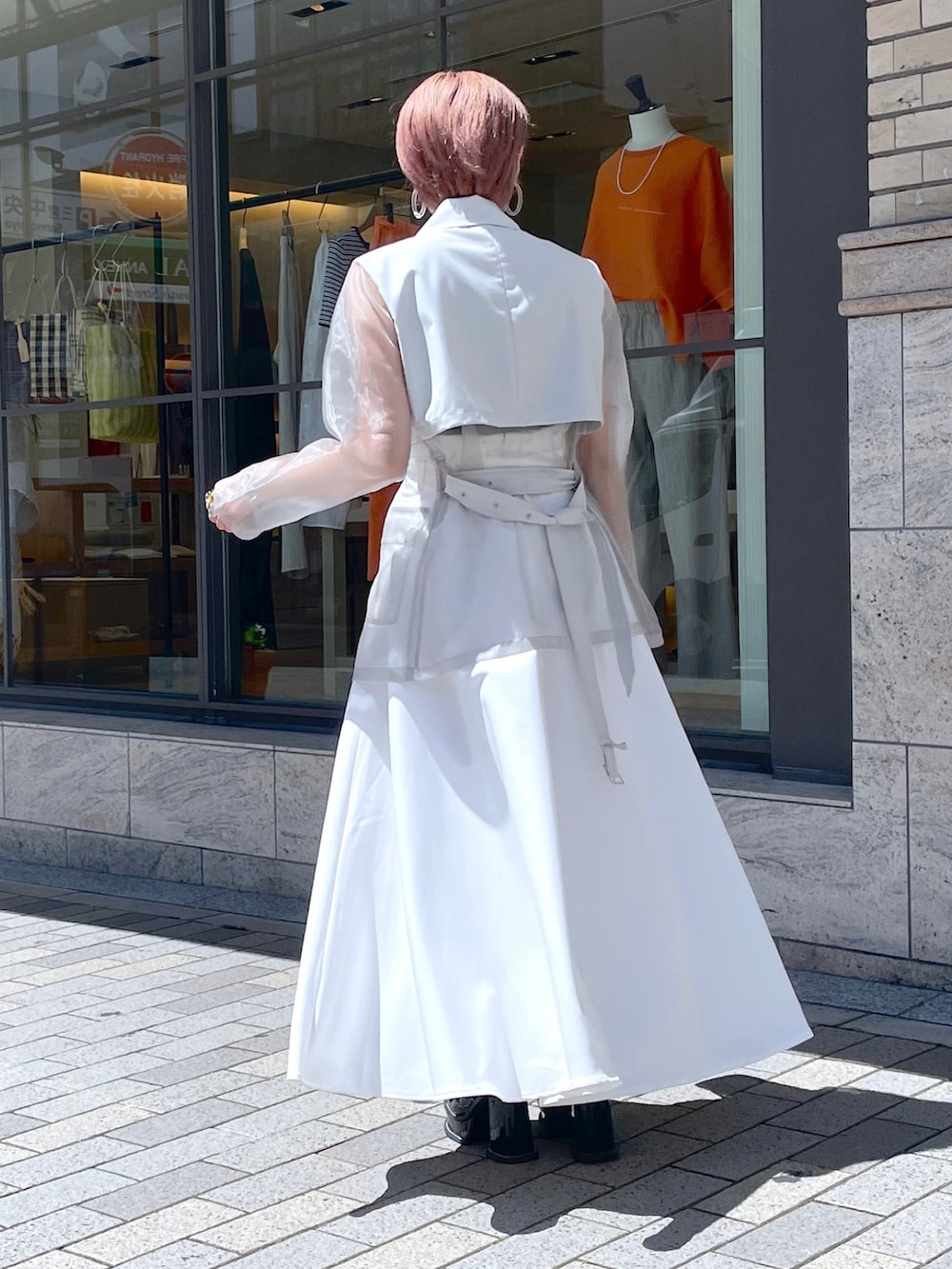 ブラック系のサンダル、ホワイト系のボストンバッグ、ベージュ系のテーラードジャケットを着用したレディースの夏コーディネートの2枚目の写真