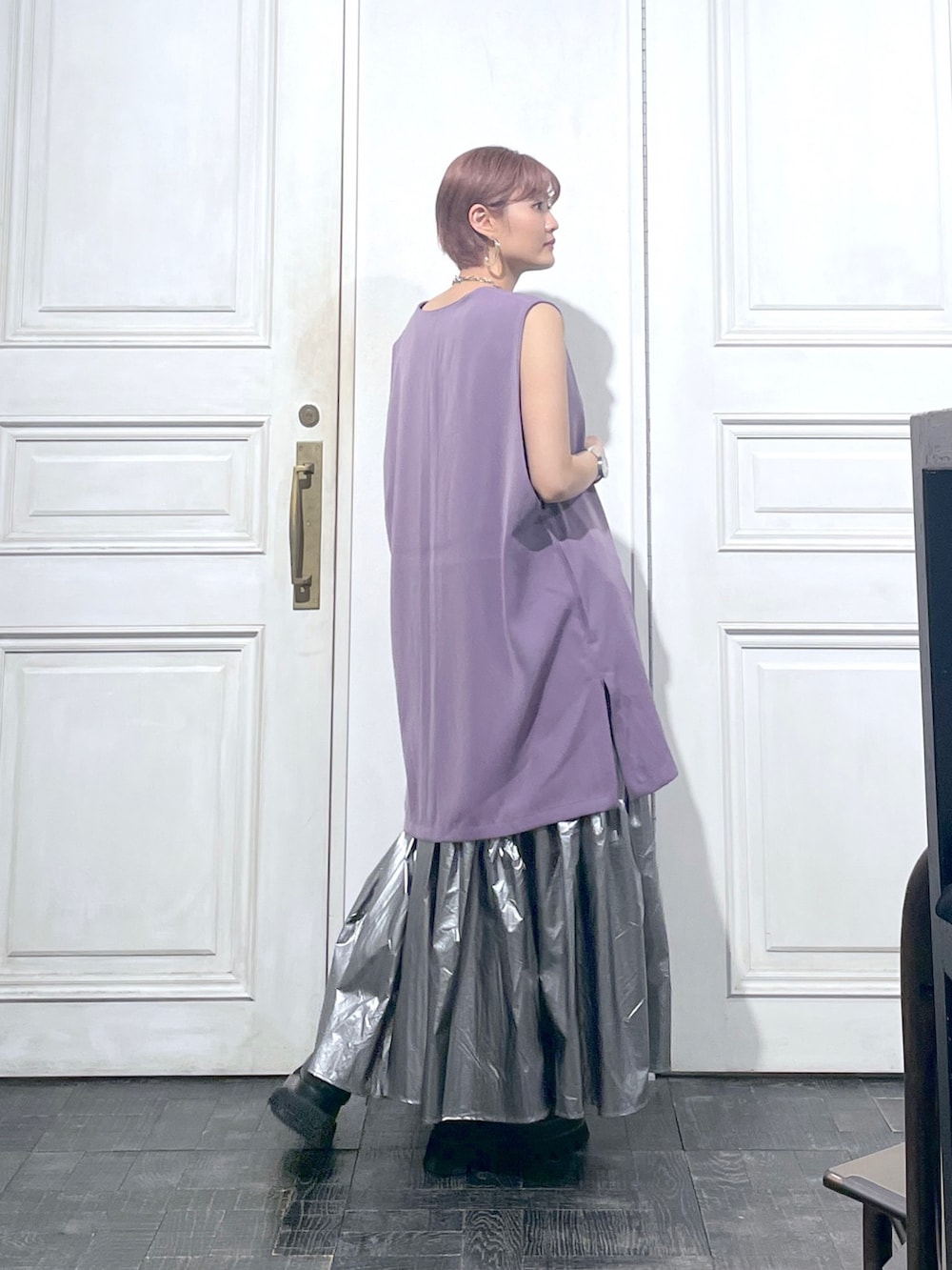 パープル系のベスト、シルバー系のスカート、ブラック系のサンダルを着用したレディースの夏コーディネートの2枚目の写真