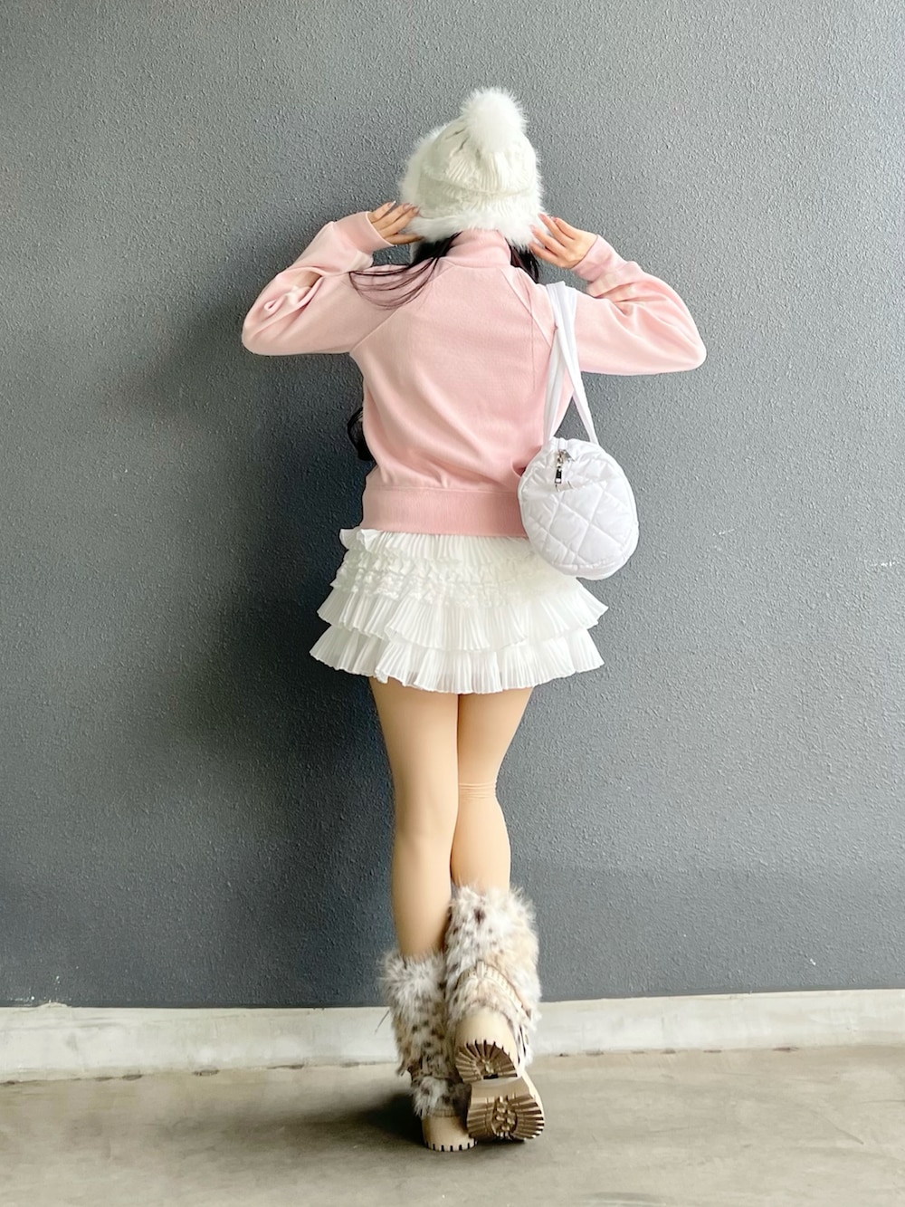 ホワイト系のスカート、ホワイト系のショルダーバッグ、ピンク系のニット/セーターを着用したレディースの春コーディネートの3枚目の写真