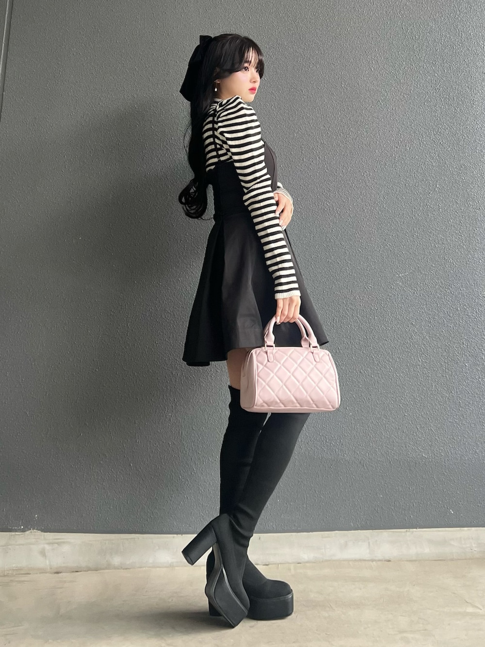 ブラック系のスカート、ブラック系のトップス、ブラック系のブーツを着用したレディースの冬コーディネートの2枚目の写真