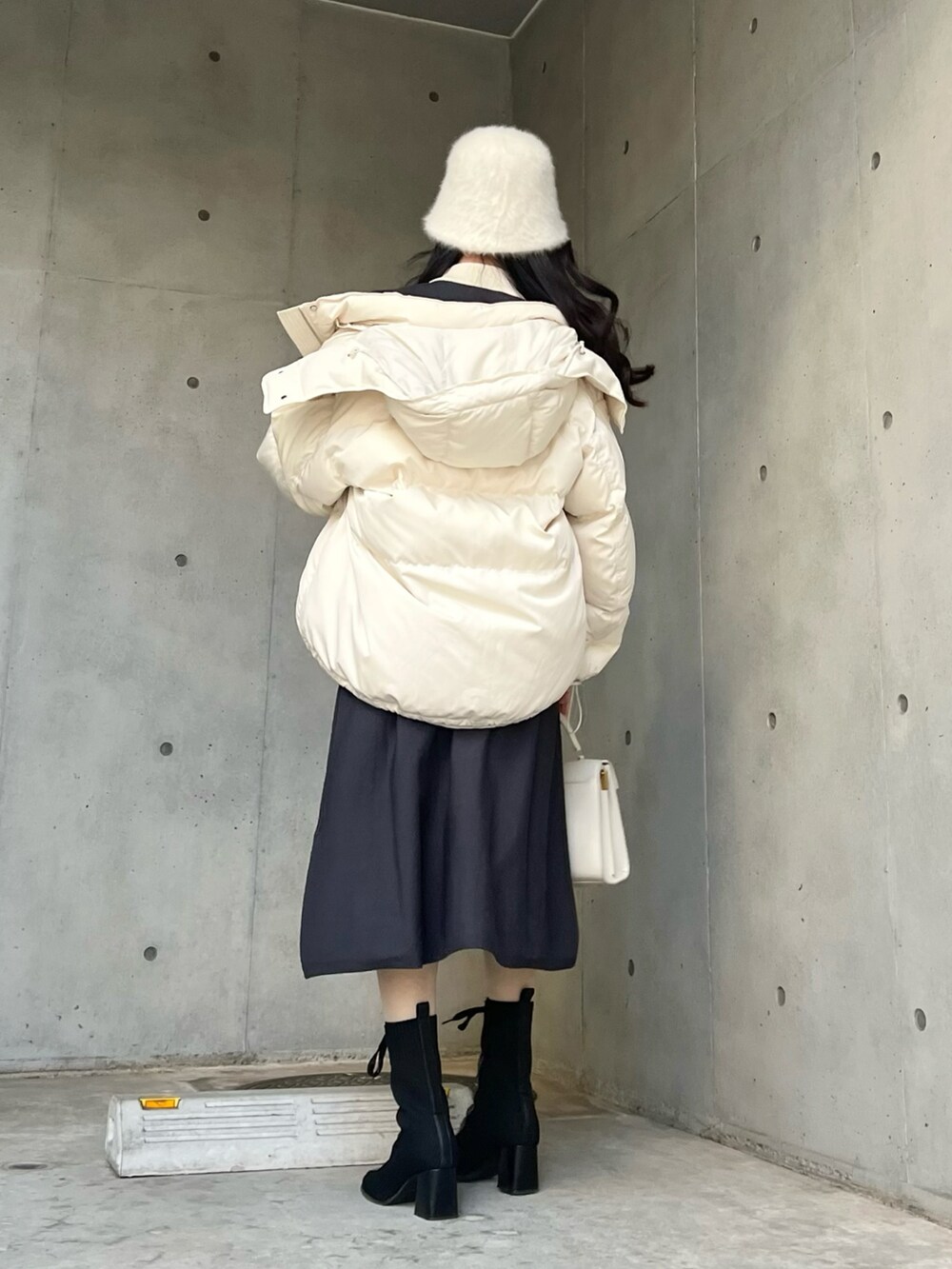 グレー系のワンピース、ホワイト系のダウンジャケット/コートを着用したレディースの冬コーディネートの5枚目の写真
