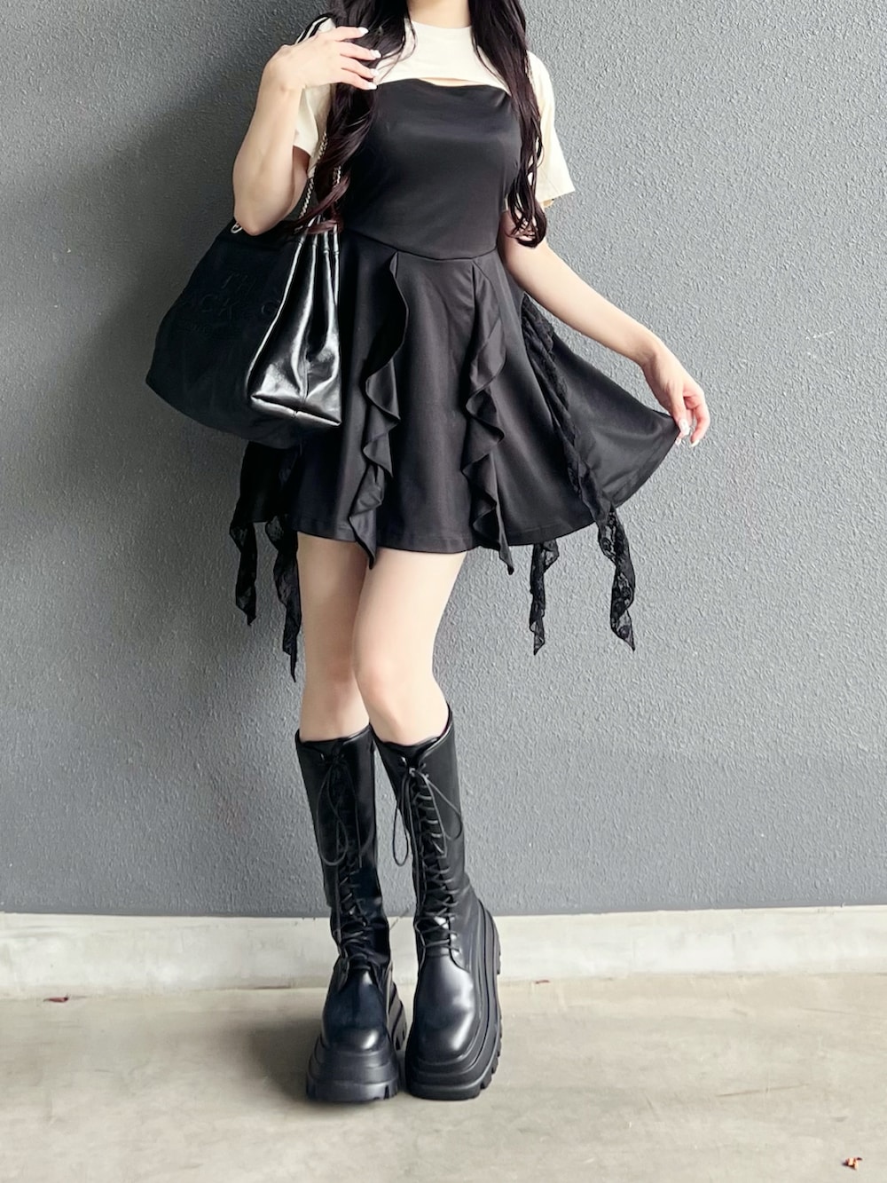 ホワイト系のTシャツ/カットソー、ブラック系のブーツ、ブラック系のショルダーバッグを着用したレディースの夏コーディネートの4枚目の写真