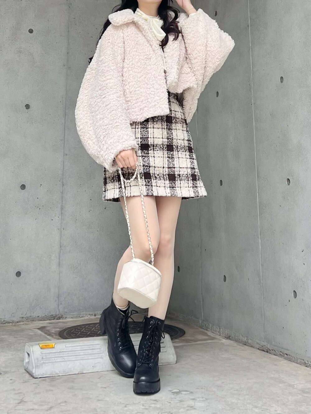 ベージュ系のスカート、ホワイト系のブルゾン、ブラック系のブーツを着用したレディースの冬コーディネートの4枚目の写真