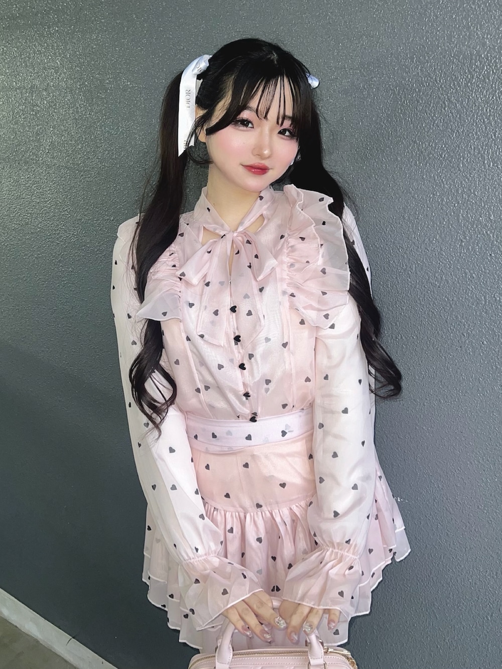 ホワイト系のスニーカー、ピンク系のトップス、ピンク系のバッグを着用したレディースの春コーディネートの5枚目の写真
