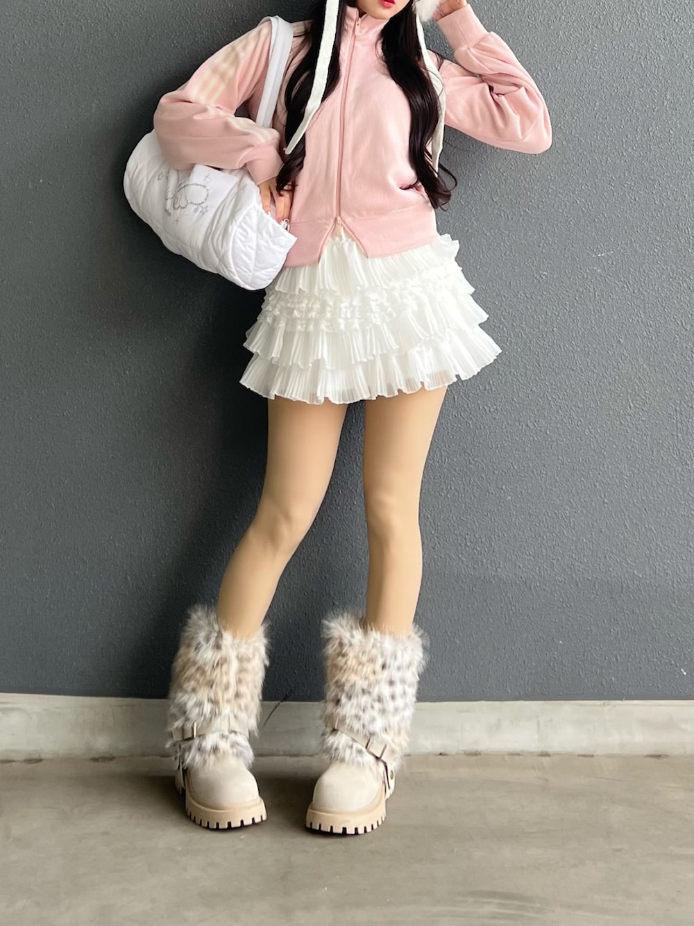 ホワイト系のスカート、ホワイト系のショルダーバッグ、ピンク系のニット/セーターを着用したレディースの春コーディネートの4枚目の写真