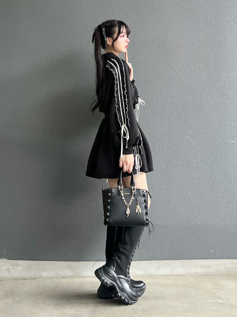 ブラック系のジャージ、ブラック系のスカート、ブラック系のバッグを着用したレディースの秋コーディネートの2枚目の写真