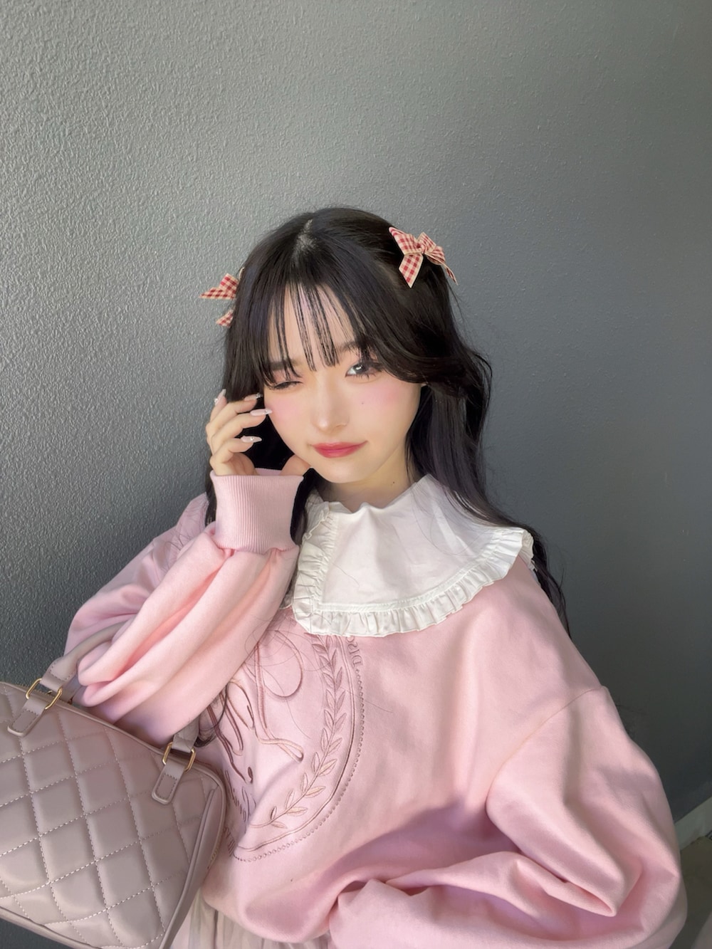 ブラック系のパンプス、ピンク系のバッグ、ピンク系のスウェットを着用したレディースの春コーディネートの5枚目の写真