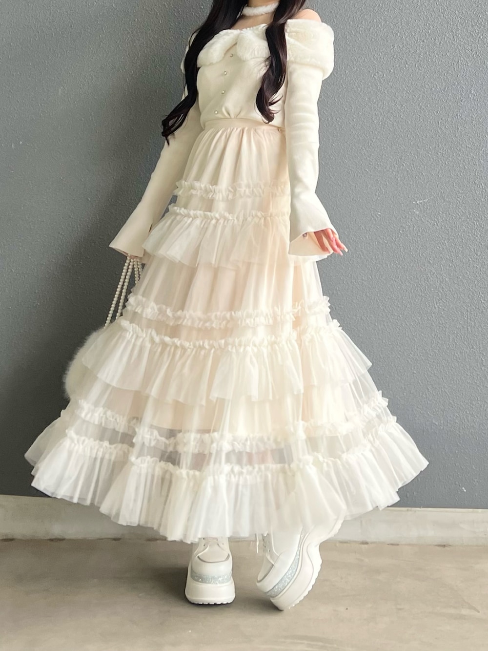 ホワイト系のスカート、ホワイト系のニット/セーター、ピンク系のシューズを着用したレディースの冬コーディネートの4枚目の写真