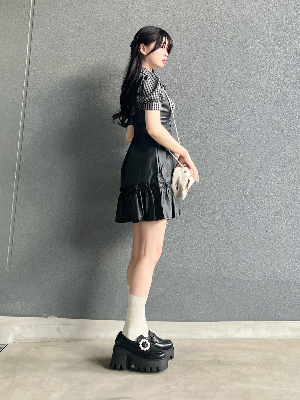 ホワイト系のトップス、ブラック系のジャンパースカート、ブラック系のシューズを着用したレディースの夏コーディネートの4枚目の写真