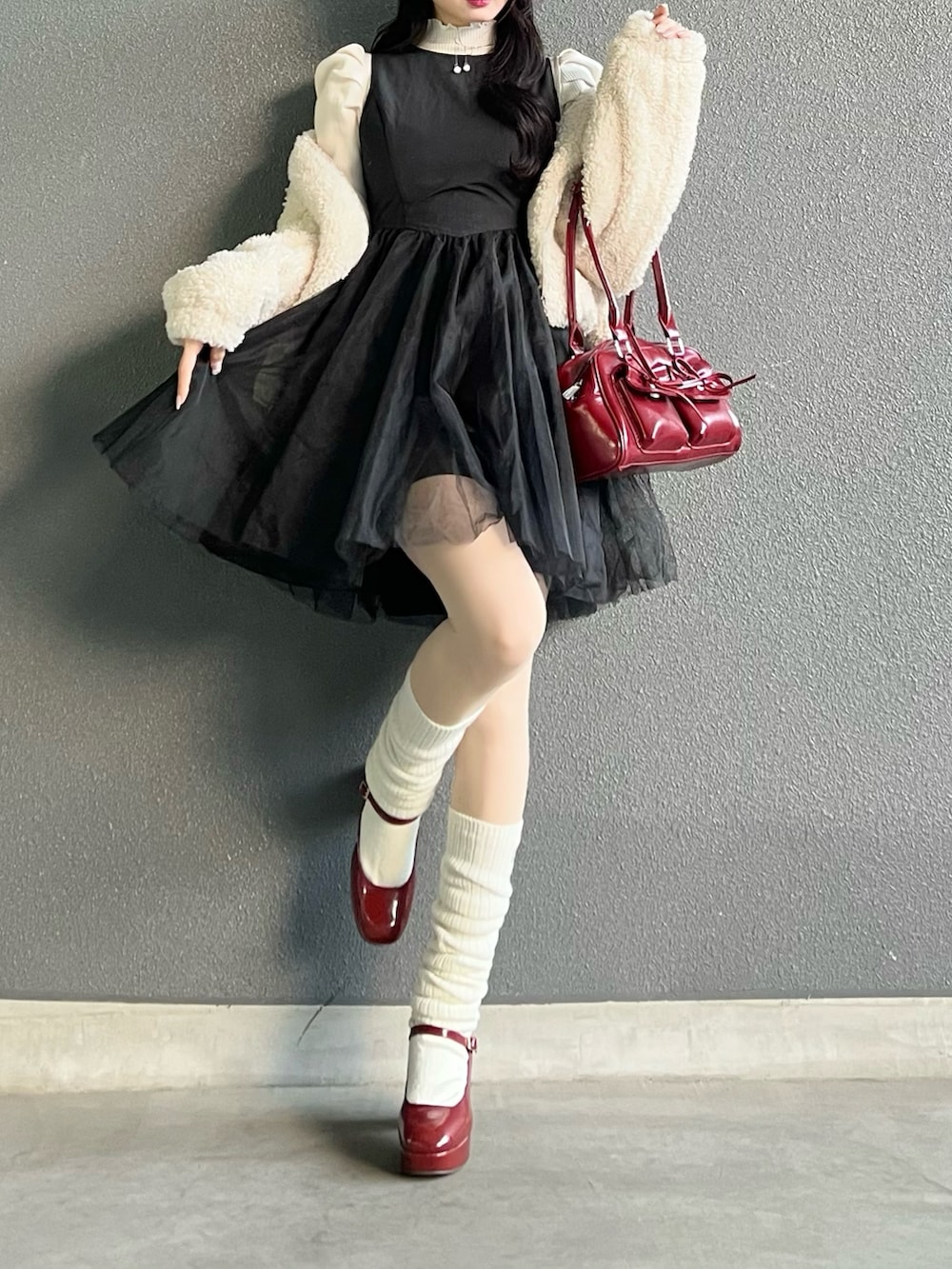 レッド系のバッグ、ホワイト系のジャケット/アウター、レッド系のパンプスを着用したレディースの冬コーディネートの4枚目の写真