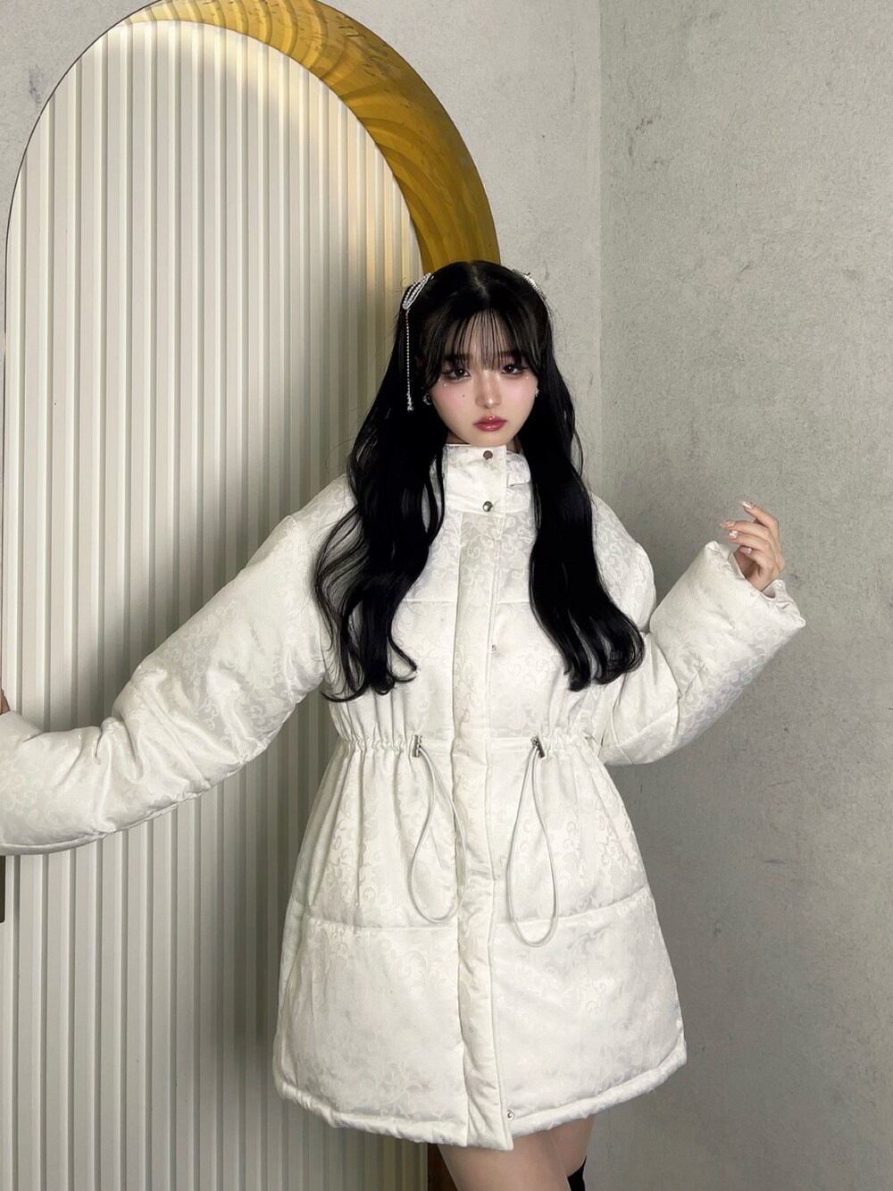 ホワイト系のジャケット/アウター、ホワイト系のバッグ、ブラック系のブーツを着用したレディースの冬コーディネートの4枚目の写真