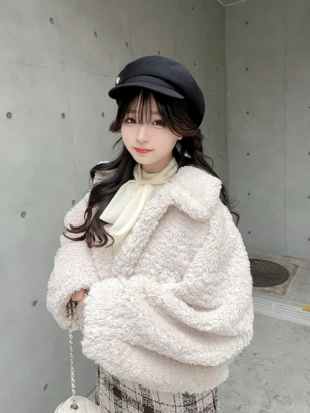 ベージュ系のスカート、ホワイト系のブルゾン、ブラック系のブーツを着用したレディースの冬コーディネートの5枚目の写真