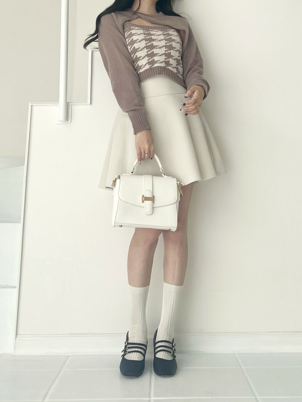 ベージュ系のニット/セーター、ホワイト系のバッグ、ホワイト系のスカートを着用したレディースの秋コーディネートの3枚目の写真