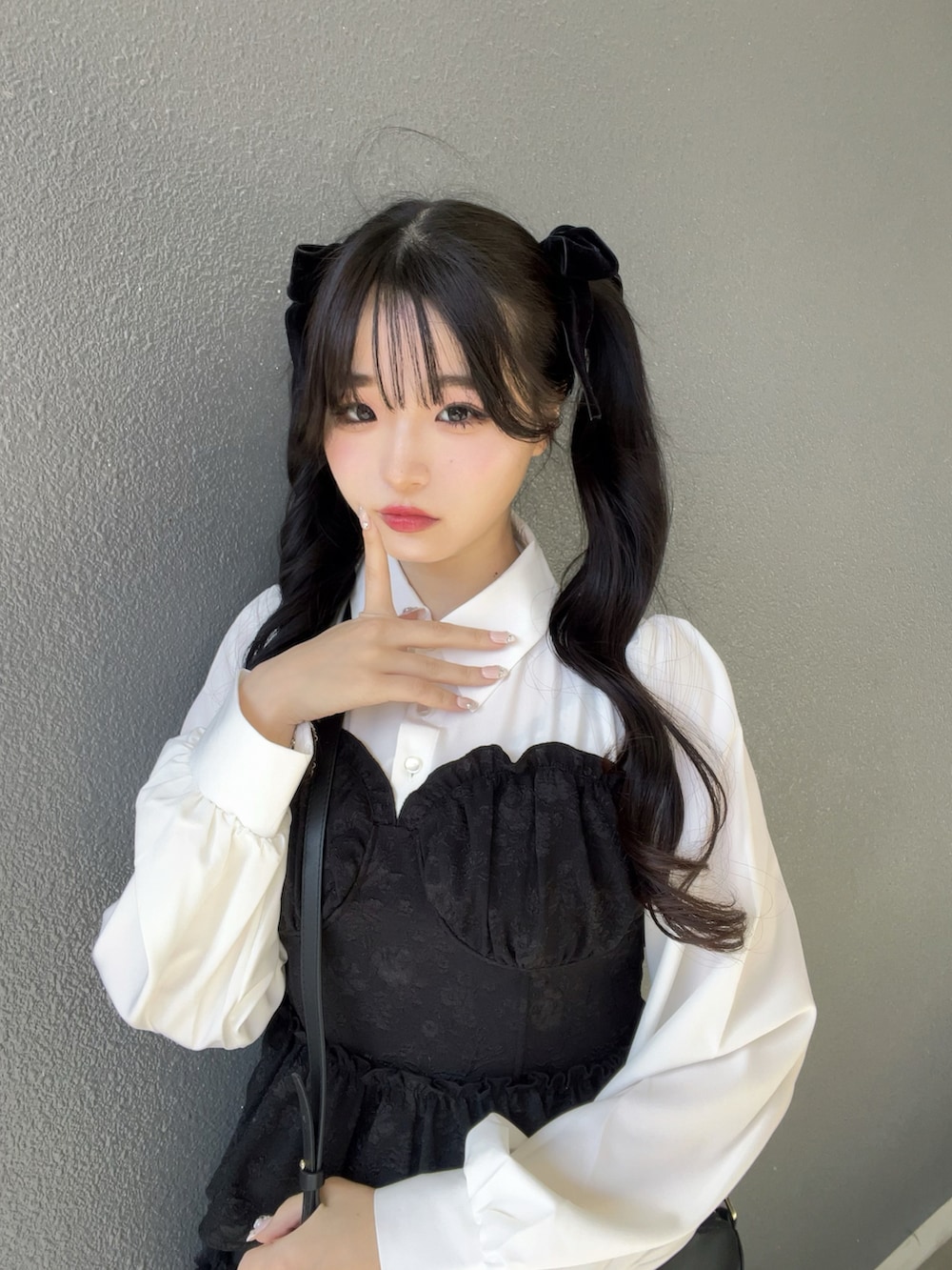 ブラック系のスカート、ブラック系のトップス、ブラック系のパンプスを着用したレディースの春コーディネートの5枚目の写真