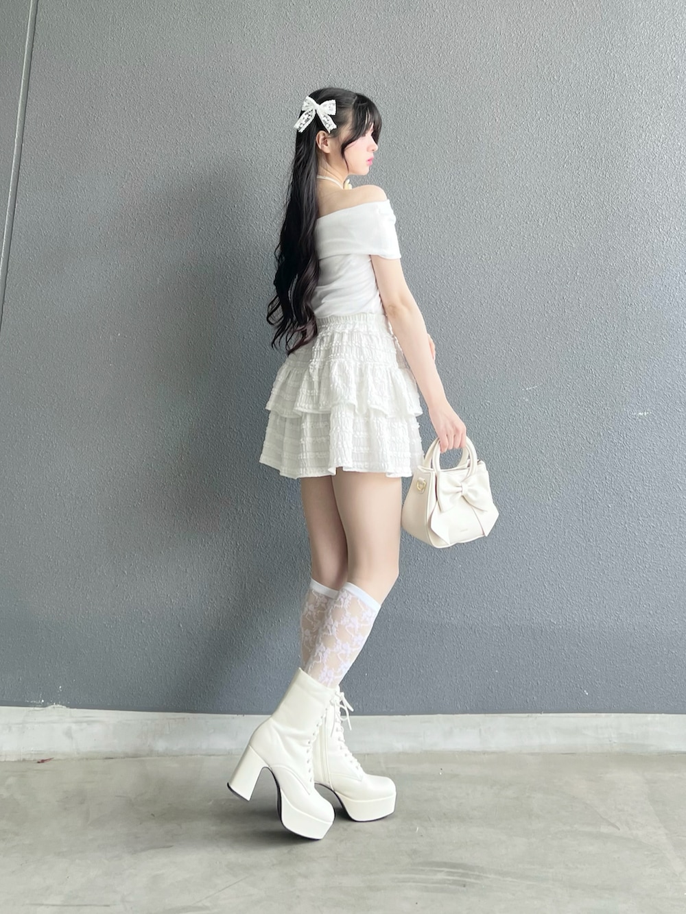 ホワイト系のスカート、ホワイト系のTシャツ/カットソー、ホワイト系のバッグを着用したレディースの夏コーディネートの2枚目の写真