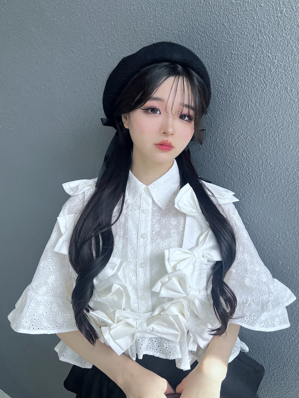 ブラック系のスカート、ホワイト系のベスト、ホワイト系のシャツ/ブラウスを着用したレディースの春コーディネートの5枚目の写真