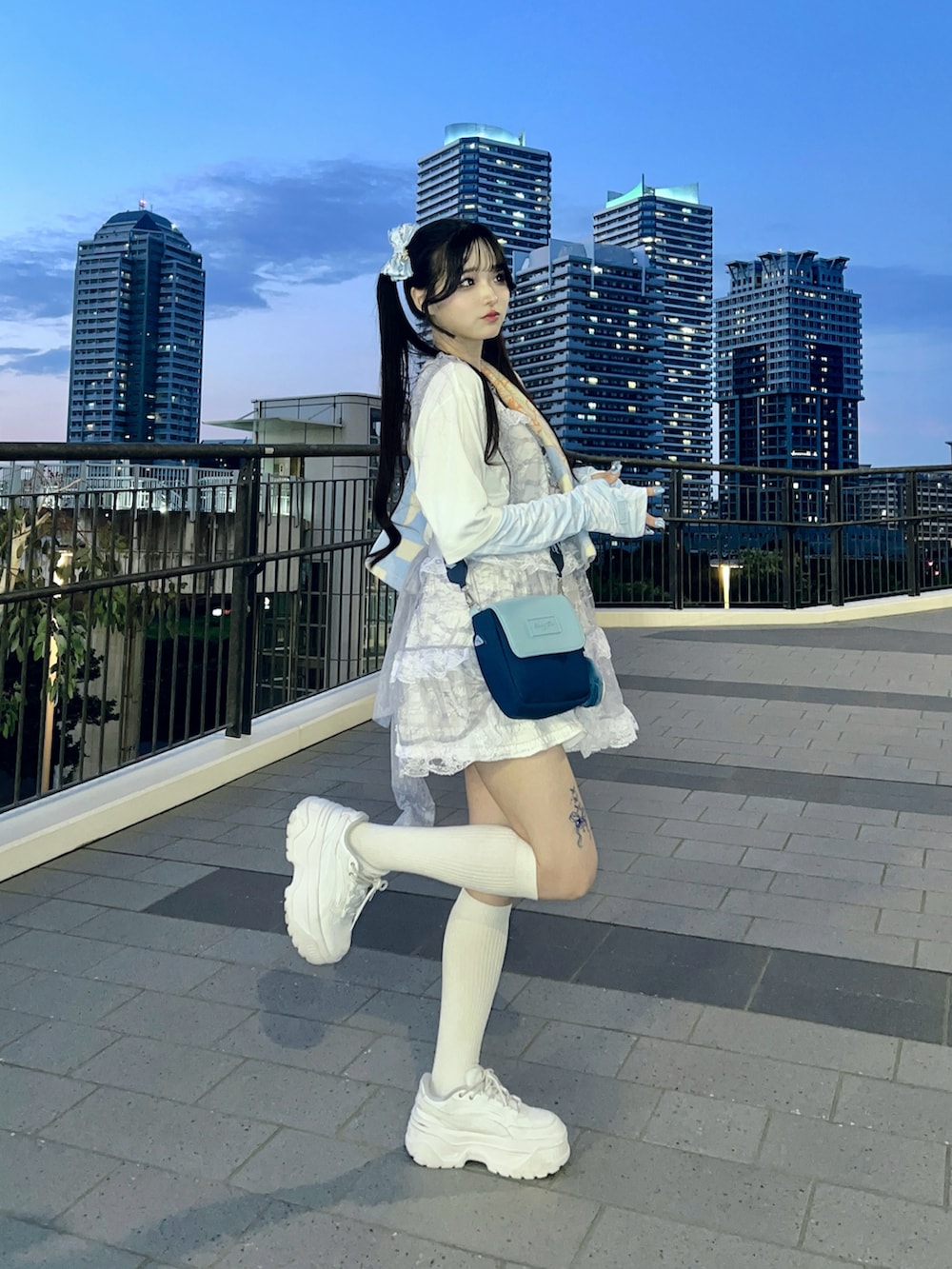 ホワイト系のスカート、ホワイト系のスニーカー、ホワイト系のTシャツ/カットソーを着用したレディースの夏コーディネートの3枚目の写真