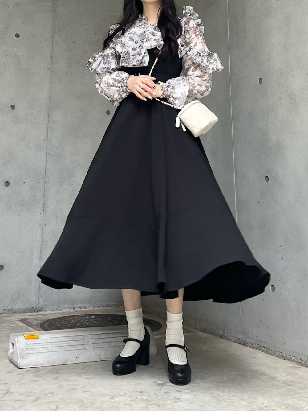 ブラック系のジャンパースカート、ブラック系のパンプス、ホワイト系のシャツ/ブラウスを着用したレディースの秋コーディネートの4枚目の写真