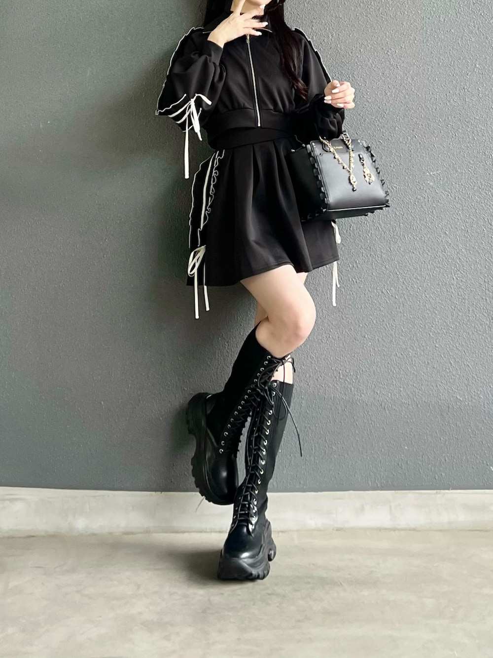 ブラック系のジャージ、ブラック系のスカート、ブラック系のバッグを着用したレディースの秋コーディネートの5枚目の写真