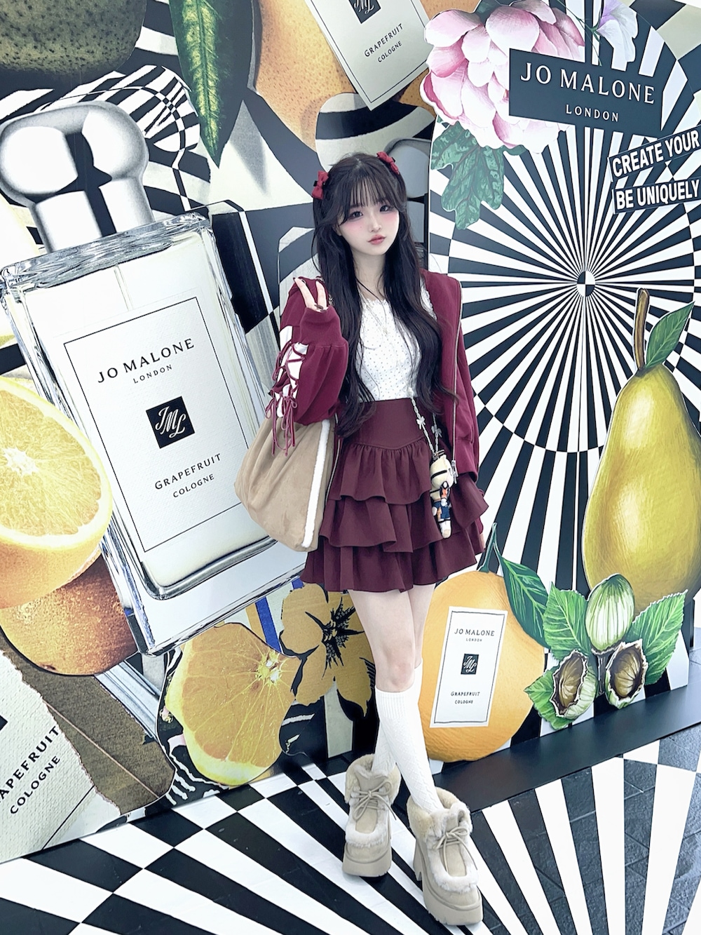 ベージュ系のブーツ、ホワイト系のタンクトップ、ピンク系のスカートを着用したレディースの秋コーディネートの2枚目の写真