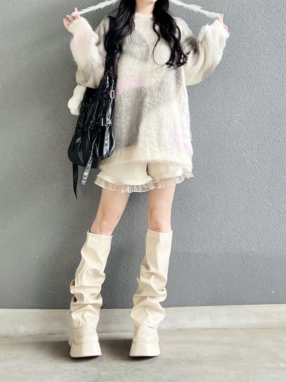 グレー系のニット/セーター、ホワイト系のその他パンツ、ホワイト系のブーツを着用したレディースの秋コーディネートの4枚目の写真