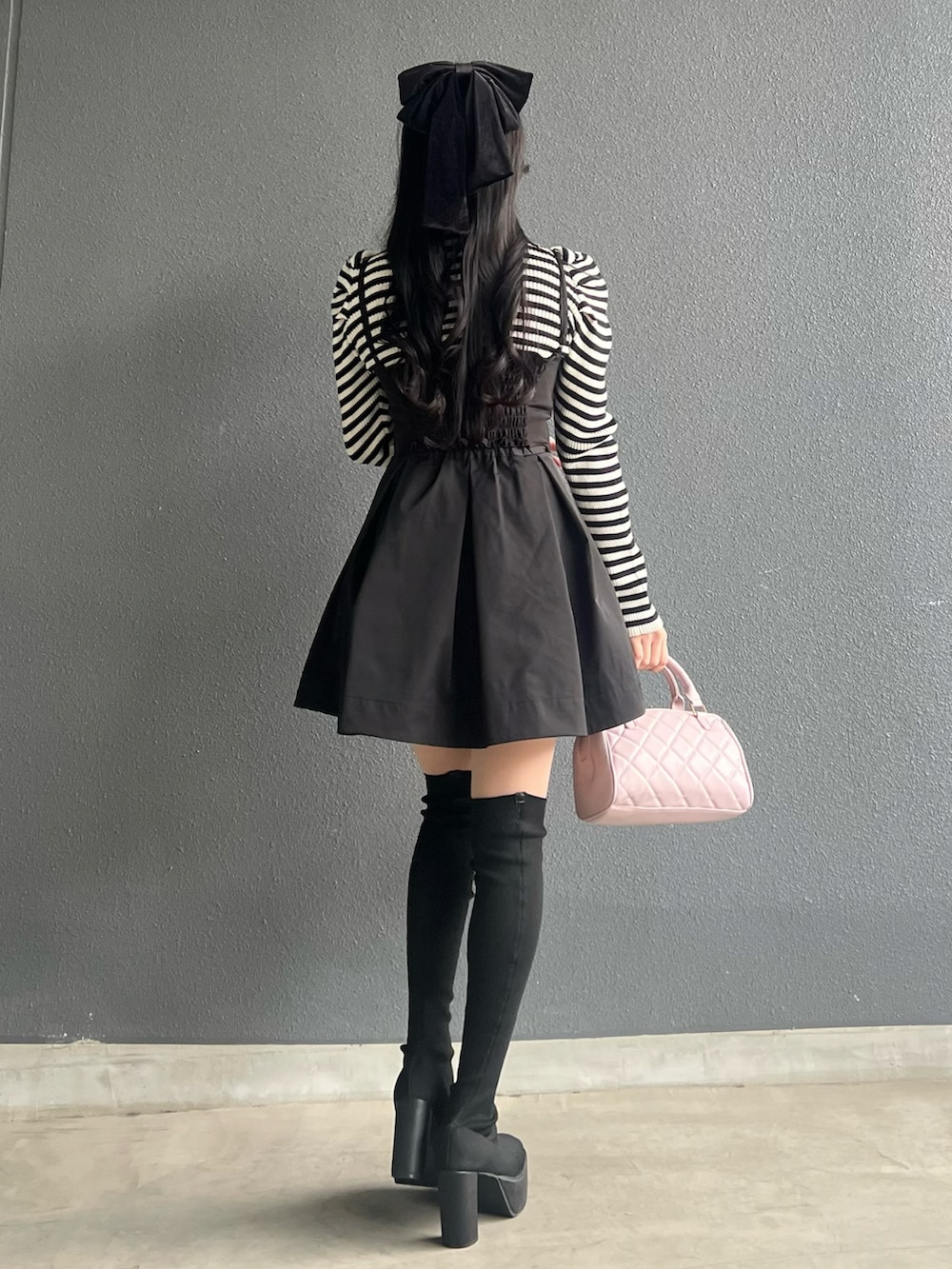 ブラック系のスカート、ブラック系のトップス、ブラック系のブーツを着用したレディースの冬コーディネートの3枚目の写真