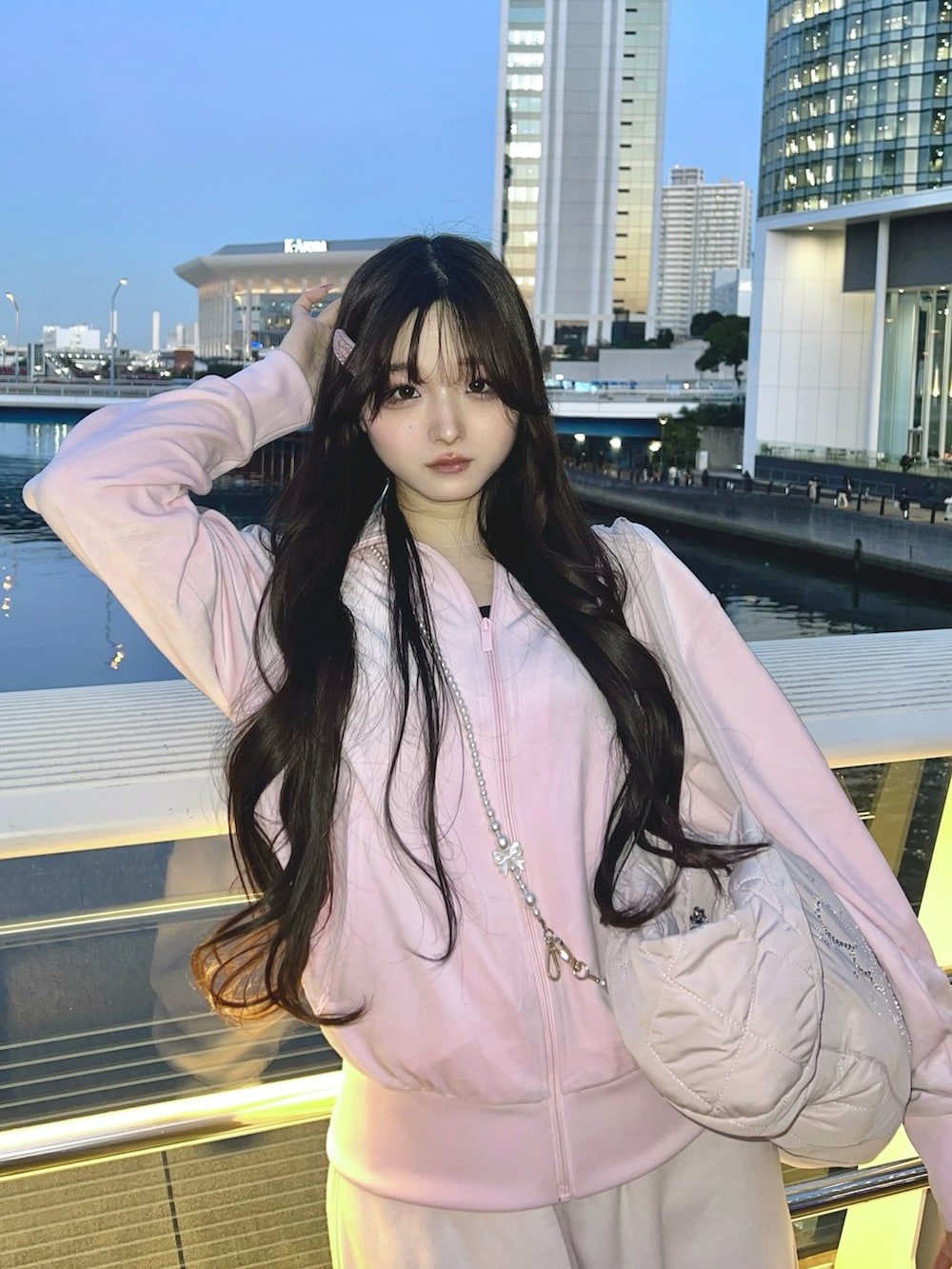 ピンク系のジャージ、ピンク系のショルダーバッグ、ピンク系のスニーカーを着用したレディースの冬コーディネートの2枚目の写真