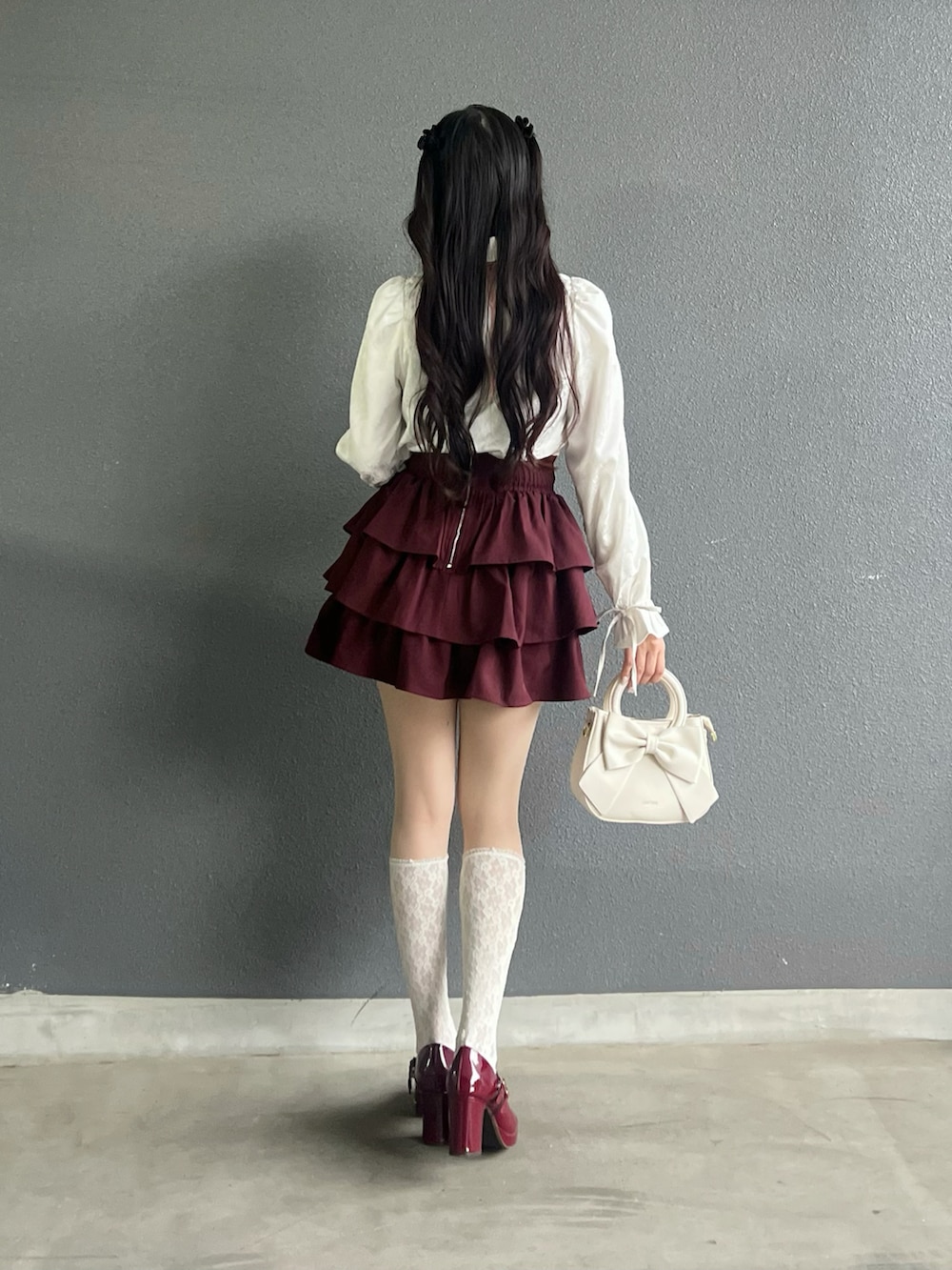 レッド系のパンプス、ホワイト系のバッグ、ホワイト系のシャツ/ブラウスを着用したレディースの秋コーディネートの3枚目の写真