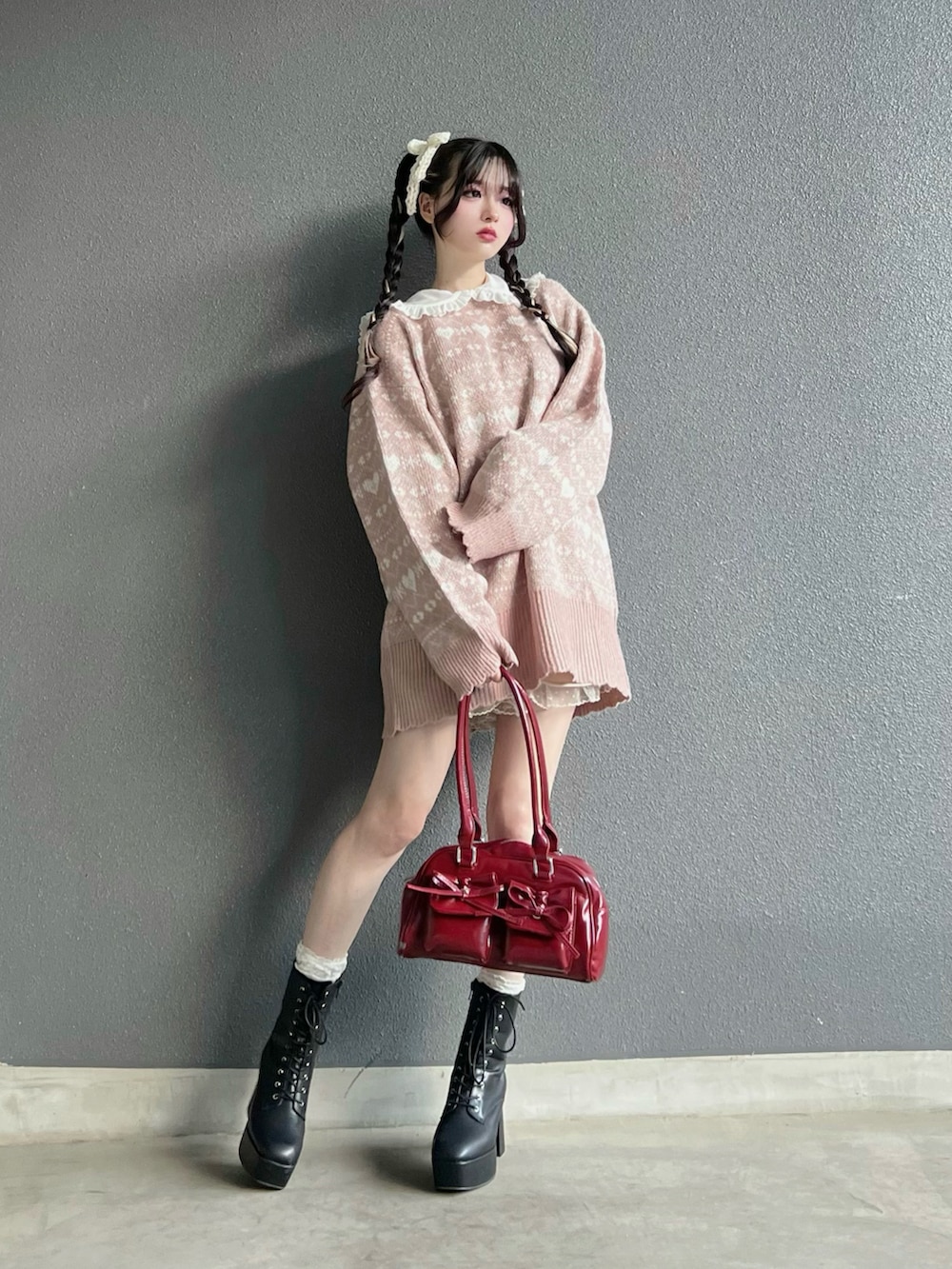 レッド系のバッグ、ブラック系のブーツ、ホワイト系のその他パンツを着用したレディースの秋コーディネートの4枚目の写真