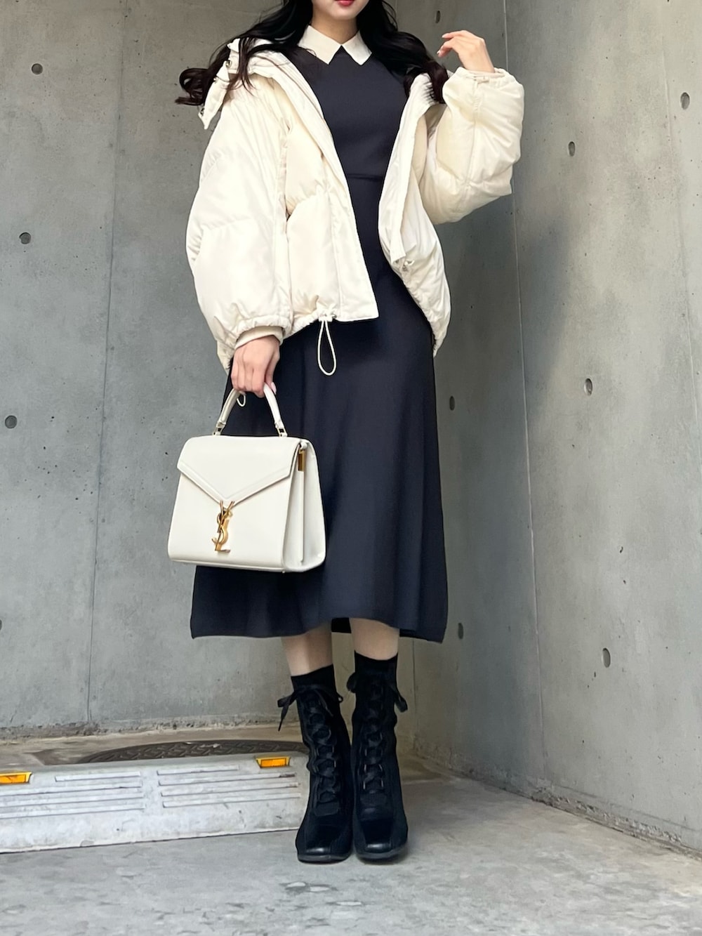 グレー系のワンピース、ホワイト系のダウンジャケット/コートを着用したレディースの冬コーディネートの3枚目の写真