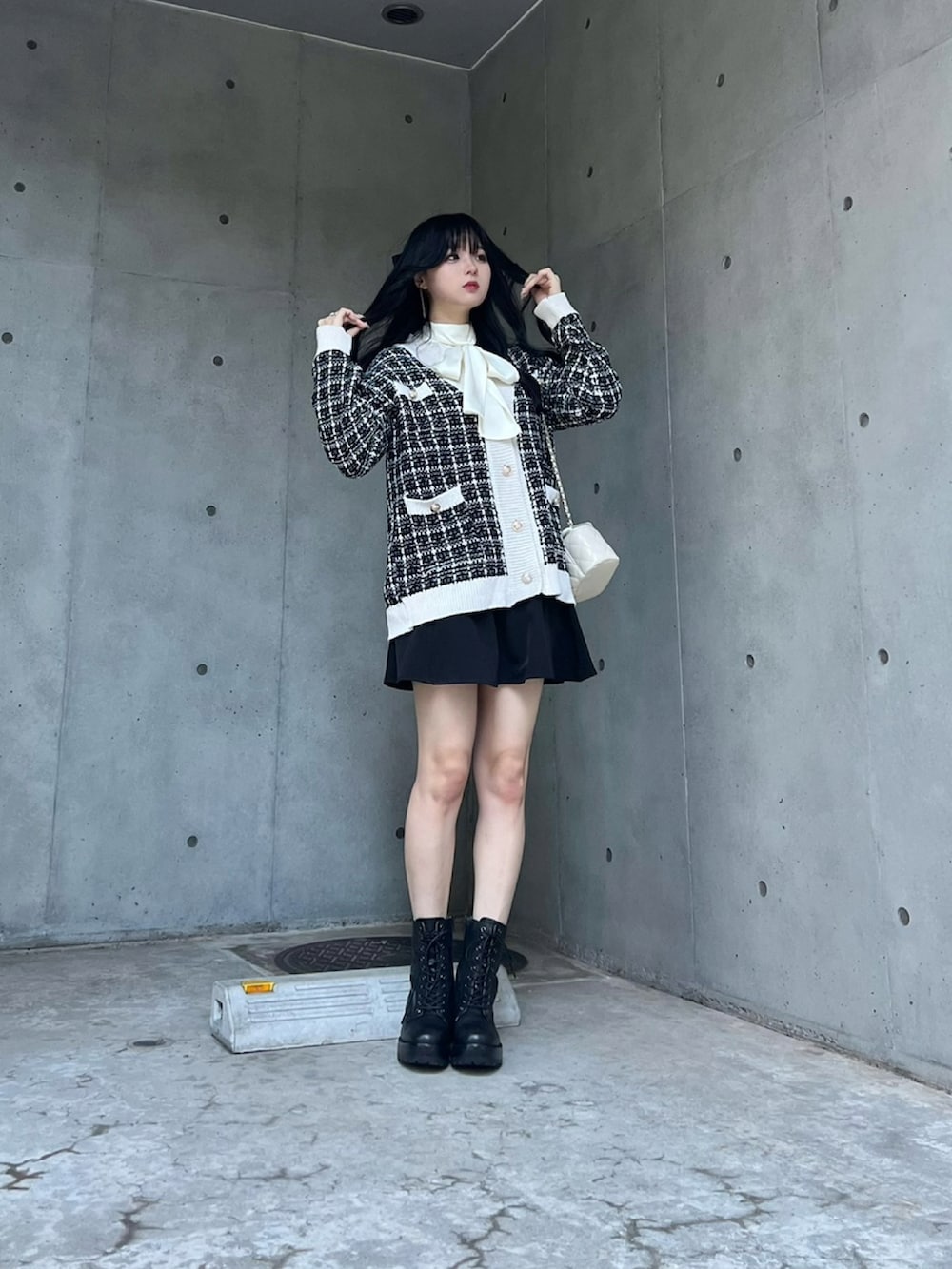 ブラック系のカーディガン/ボレロ、ホワイト系のシャツ/ブラウス、ブラック系のスカートを着用したレディースの秋コーディネートの2枚目の写真