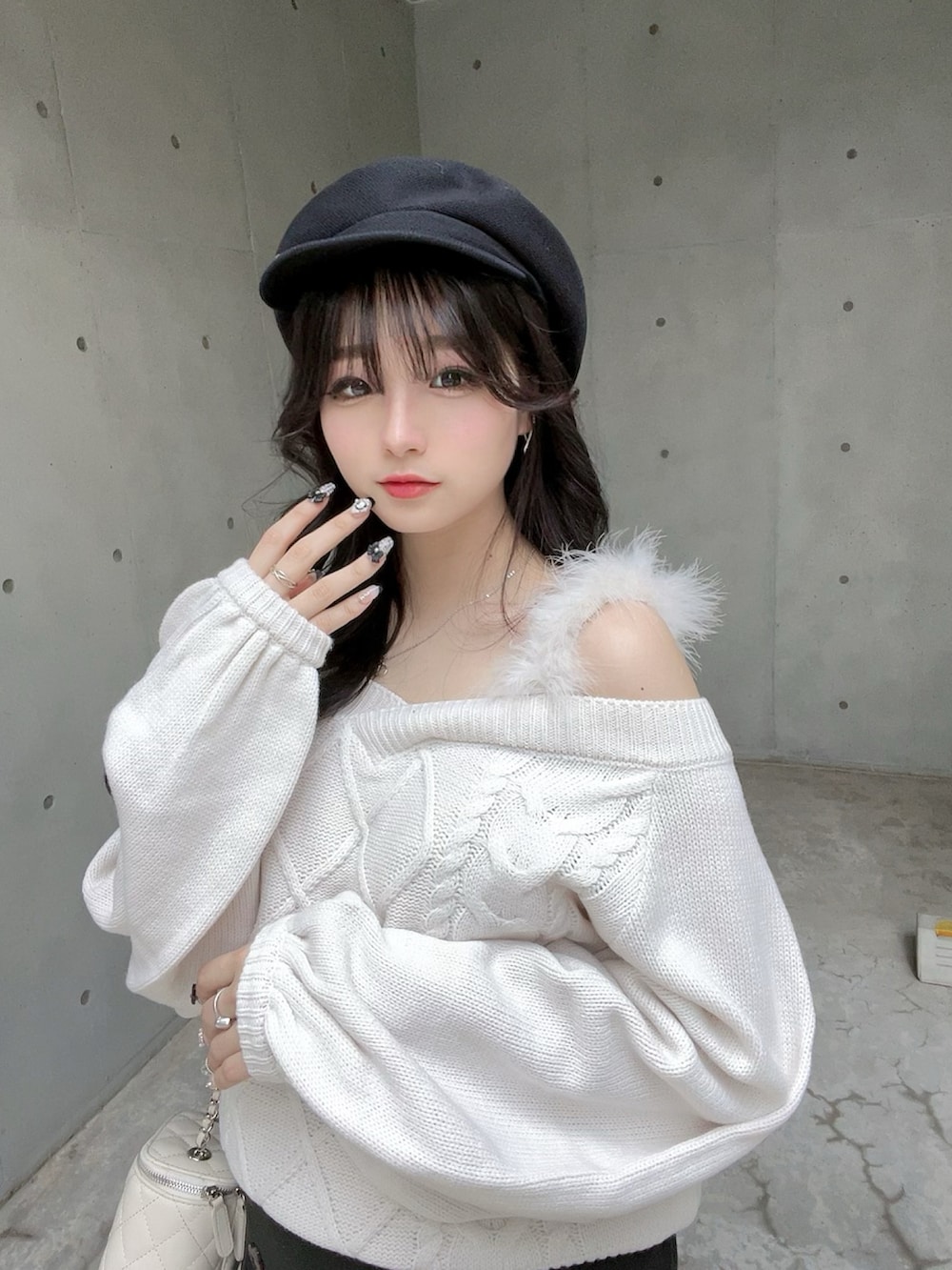 ホワイト系のニット/セーター、ブラック系のスカート、ブラック系のブーツを着用したレディースの秋コーディネートの5枚目の写真