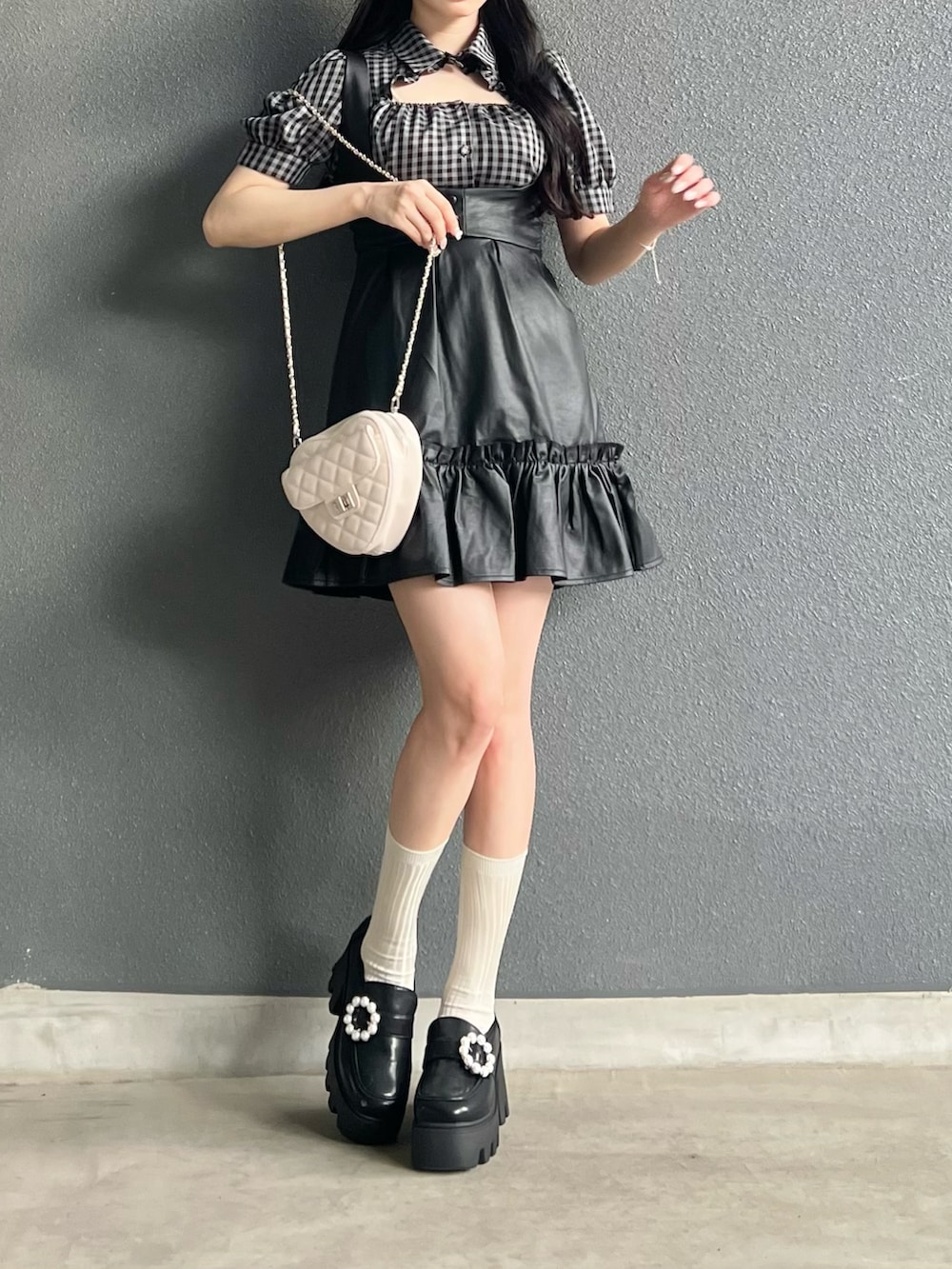 ホワイト系のトップス、ブラック系のジャンパースカート、ブラック系のシューズを着用したレディースの夏コーディネートの2枚目の写真