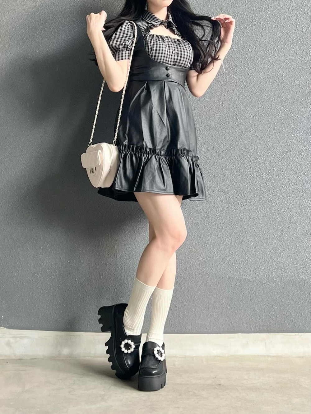 ホワイト系のトップス、ブラック系のジャンパースカート、ブラック系のシューズを着用したレディースの夏コーディネートの3枚目の写真