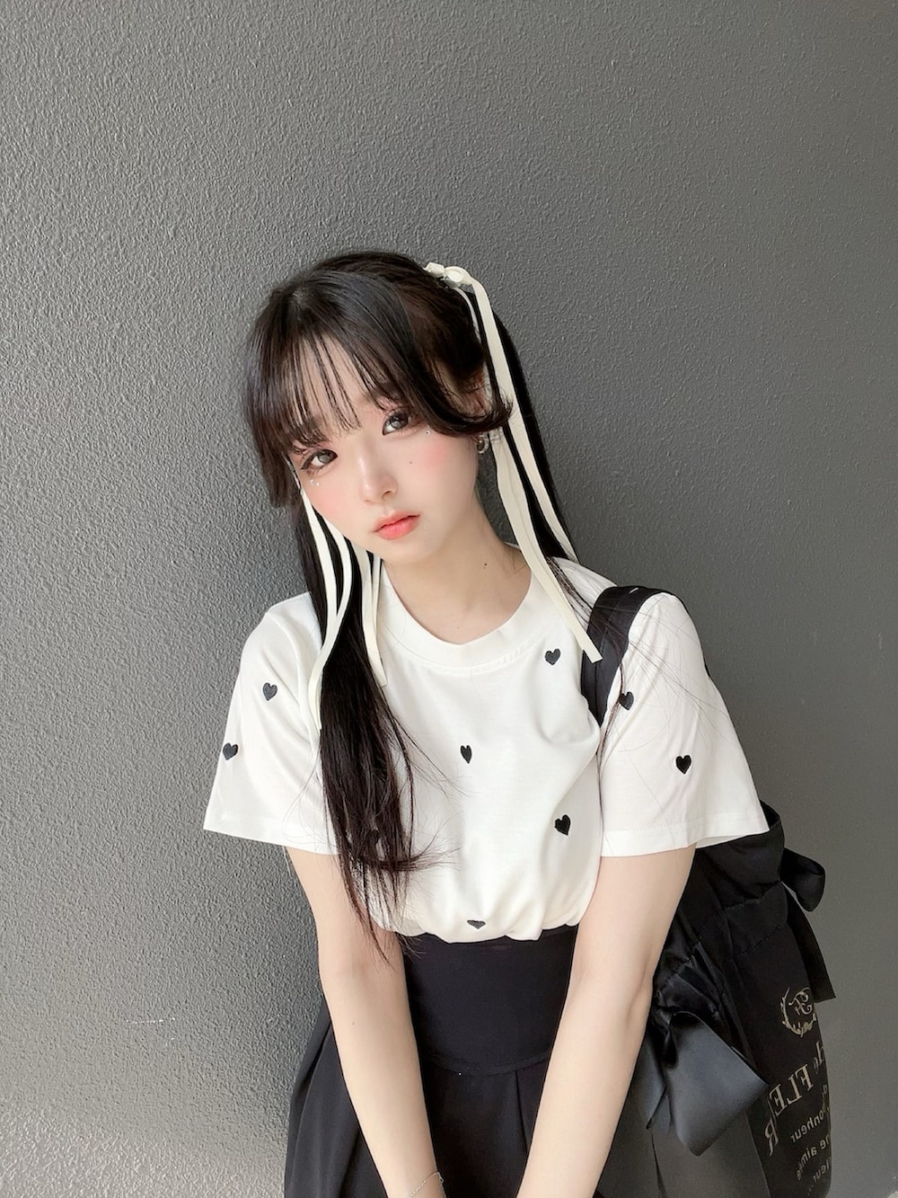 ブラック系のバッグ、ホワイト系のTシャツ/カットソー、ホワイト系のスニーカーを着用したレディースの夏コーディネートの5枚目の写真