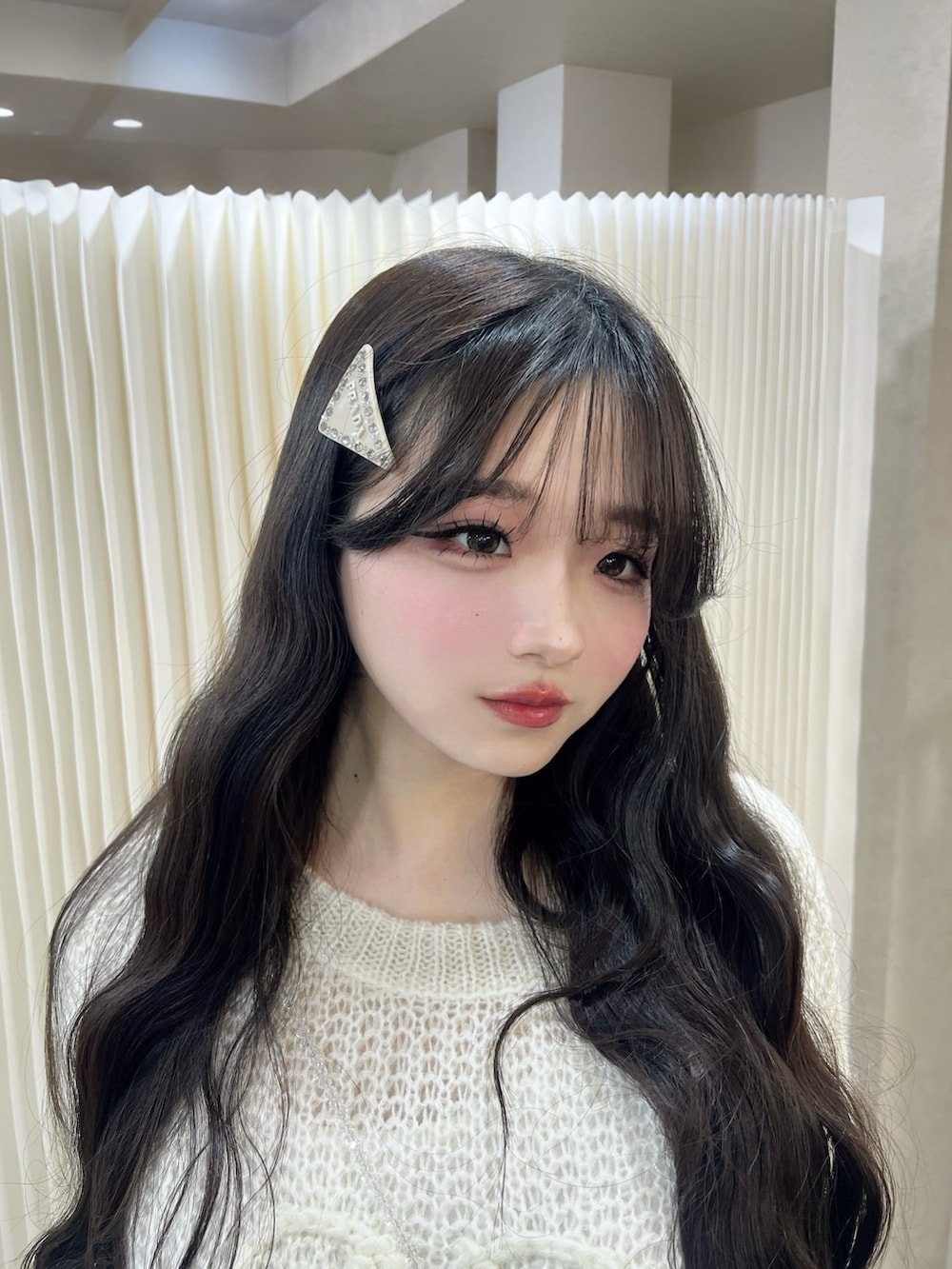 ホワイト系のブーツ、ブラック系のその他パンツ、ホワイト系のニット/セーターを着用したレディースの冬コーディネートの2枚目の写真