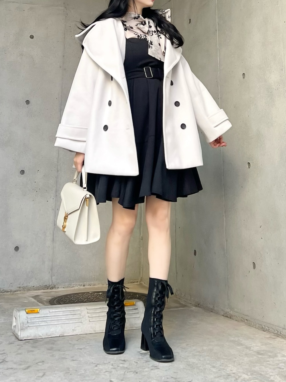ブラック系のシャツ/ブラウス、ホワイト系のジャケット/アウター、ブラック系のジャンパースカートを着用したレディースの秋コーディネートの2枚目の写真