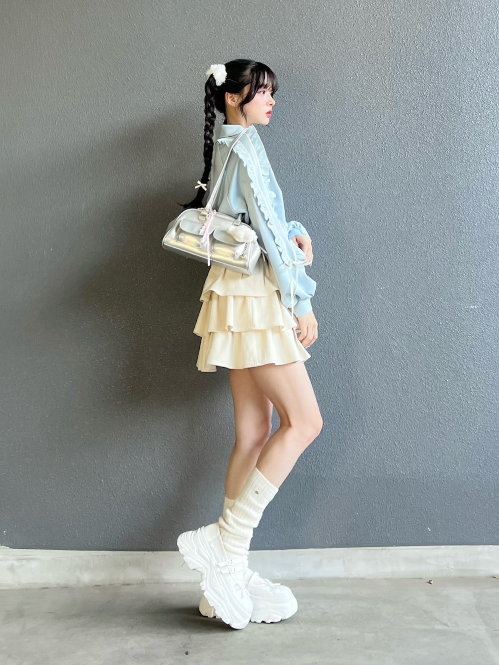 ブルー系のジャージ、ホワイト系のスカート、ホワイト系のシューズを着用したレディースの秋コーディネートの2枚目の写真